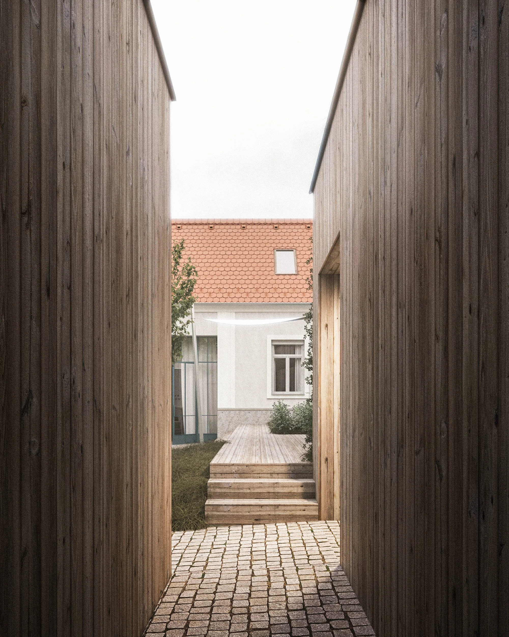 Narrow outdoor corridor between two wooden buildings with a wooden deck and cobblestone pathway leading toward a building with a red tile roof and windows.
