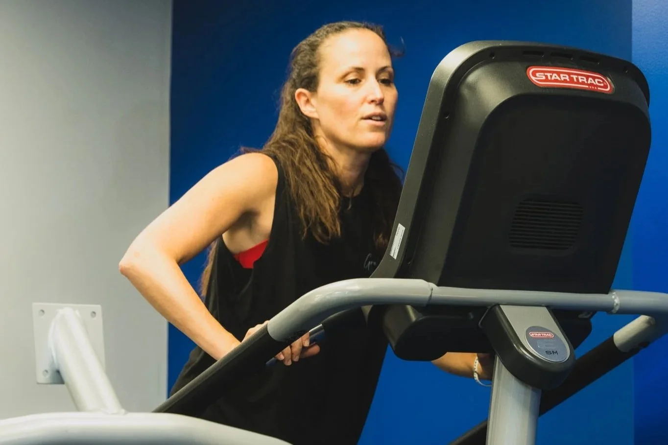 Woman exercising on a treadmill in a gym.