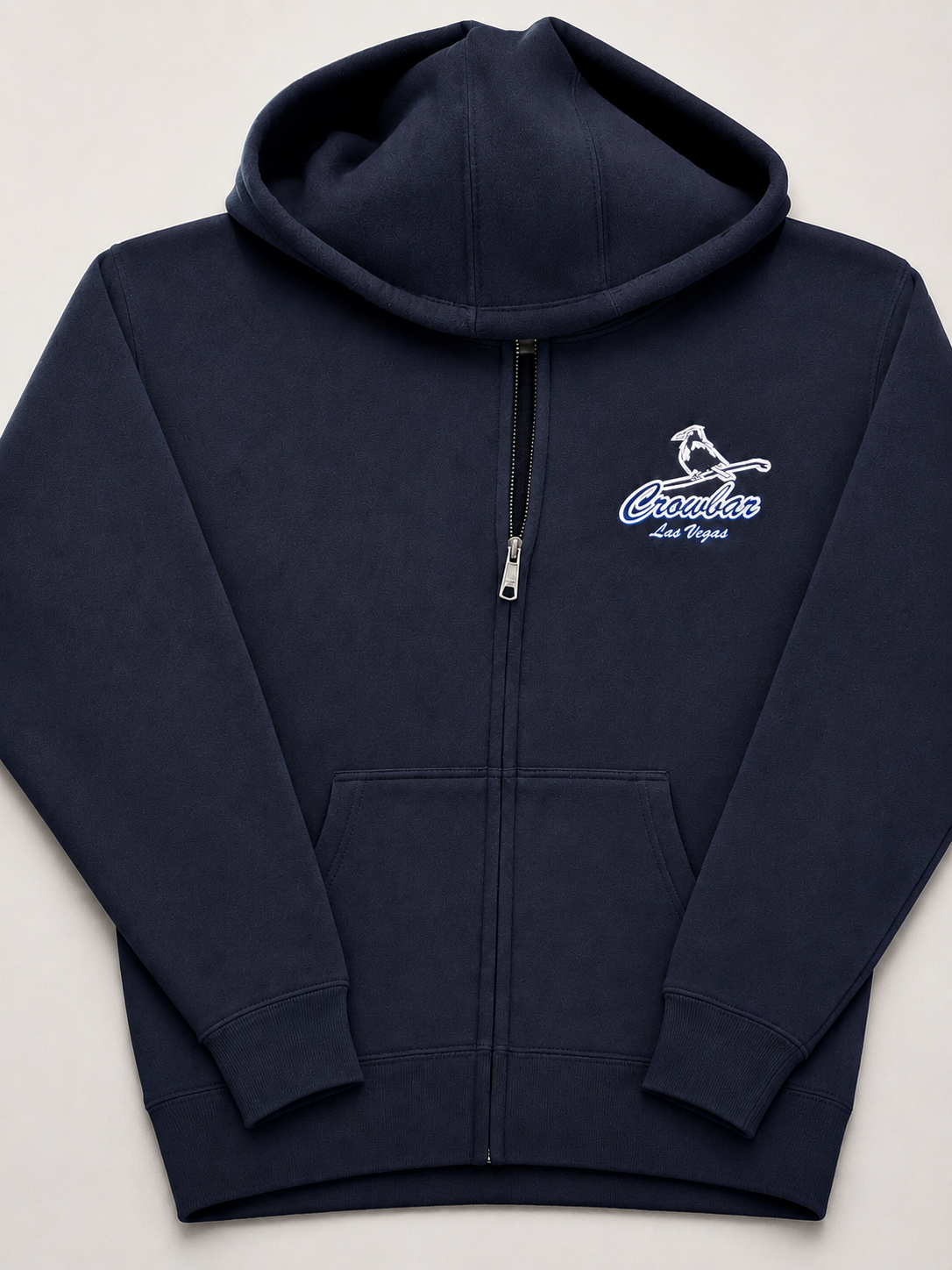 Navy blue zip-up hoodie with a front pocket and a logo on the left chest that says "Crawbac Las Vegas" with an image of a bird.