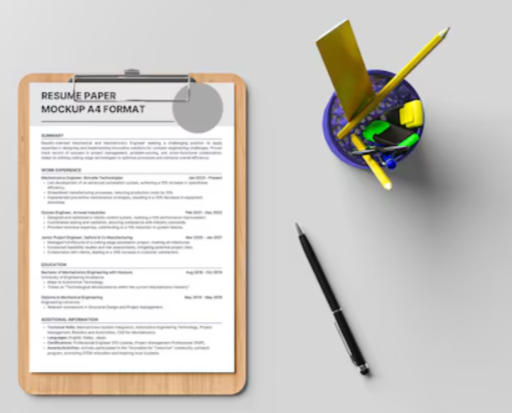 Resuming paper on a clipboard, a black pen, and a pencil holder with yellow pencils, scissors, and a notebook on a gray surface.