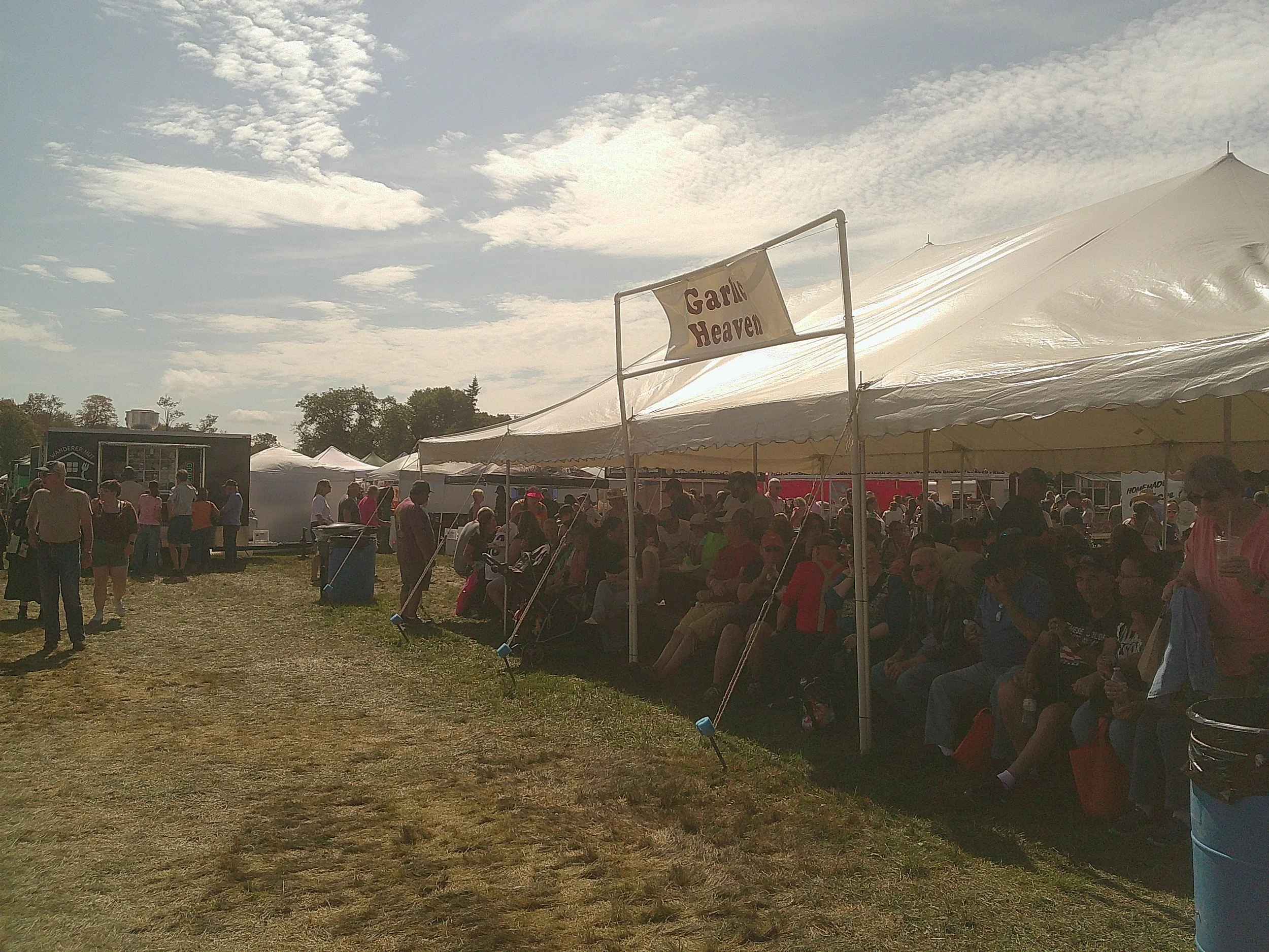 A tent full of people, above which is a sign that reads "Garlic Heaven."