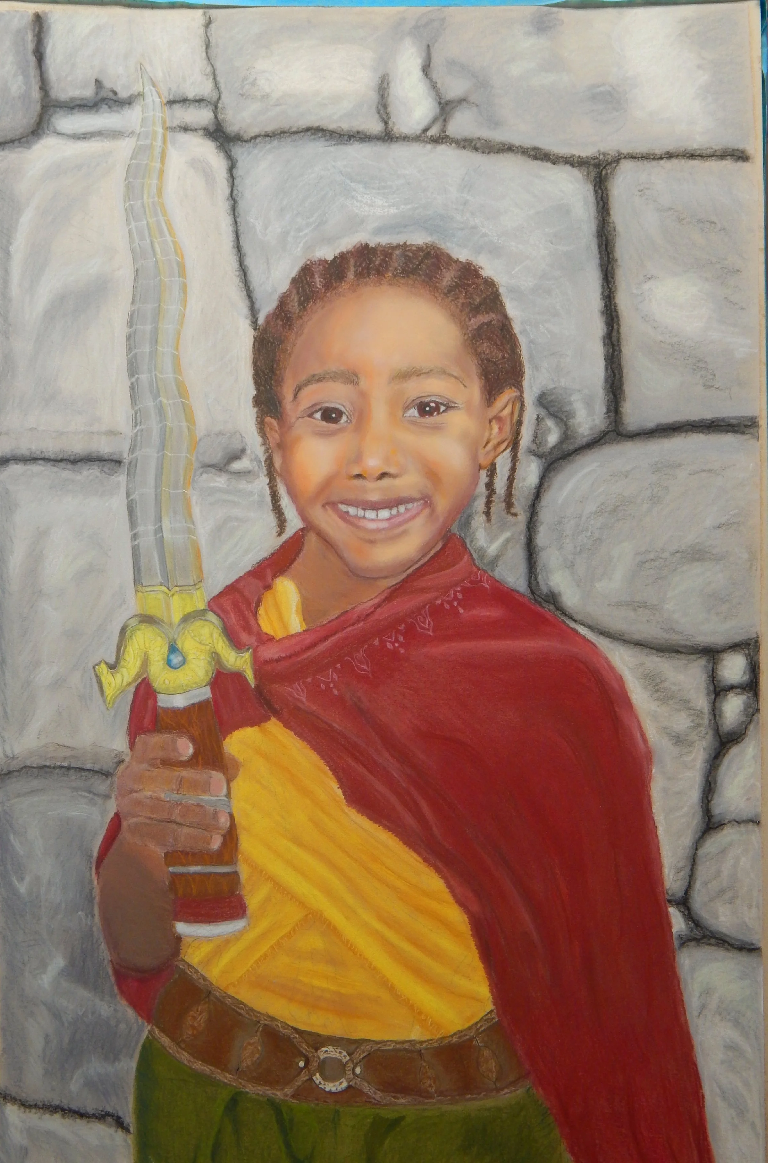 A smiling young child wearing a flowing red cape holds a toy sword while looking confidently toward the viewer.