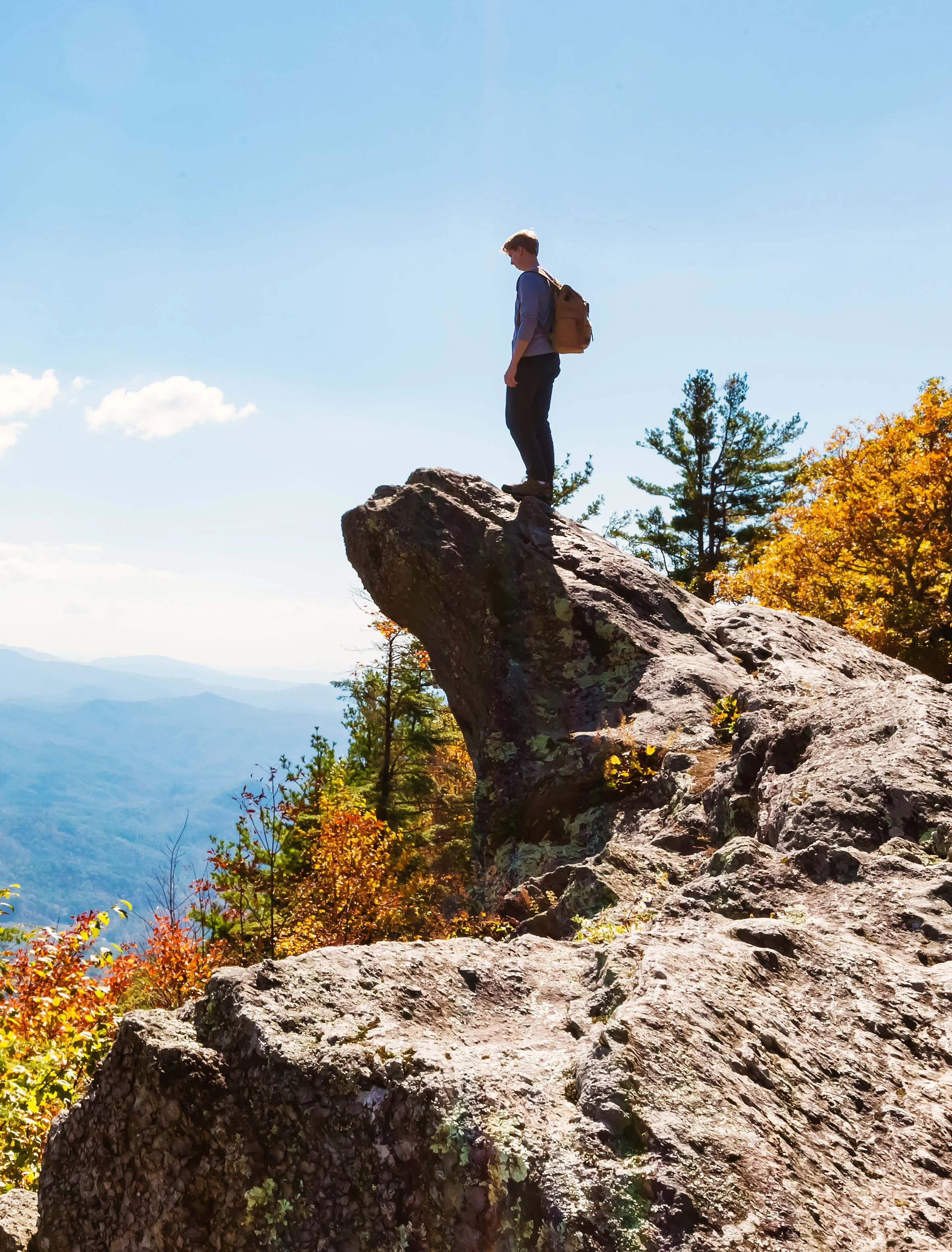 Young hiker standing on a rocky overlook above the Blue Ridge Mountains.