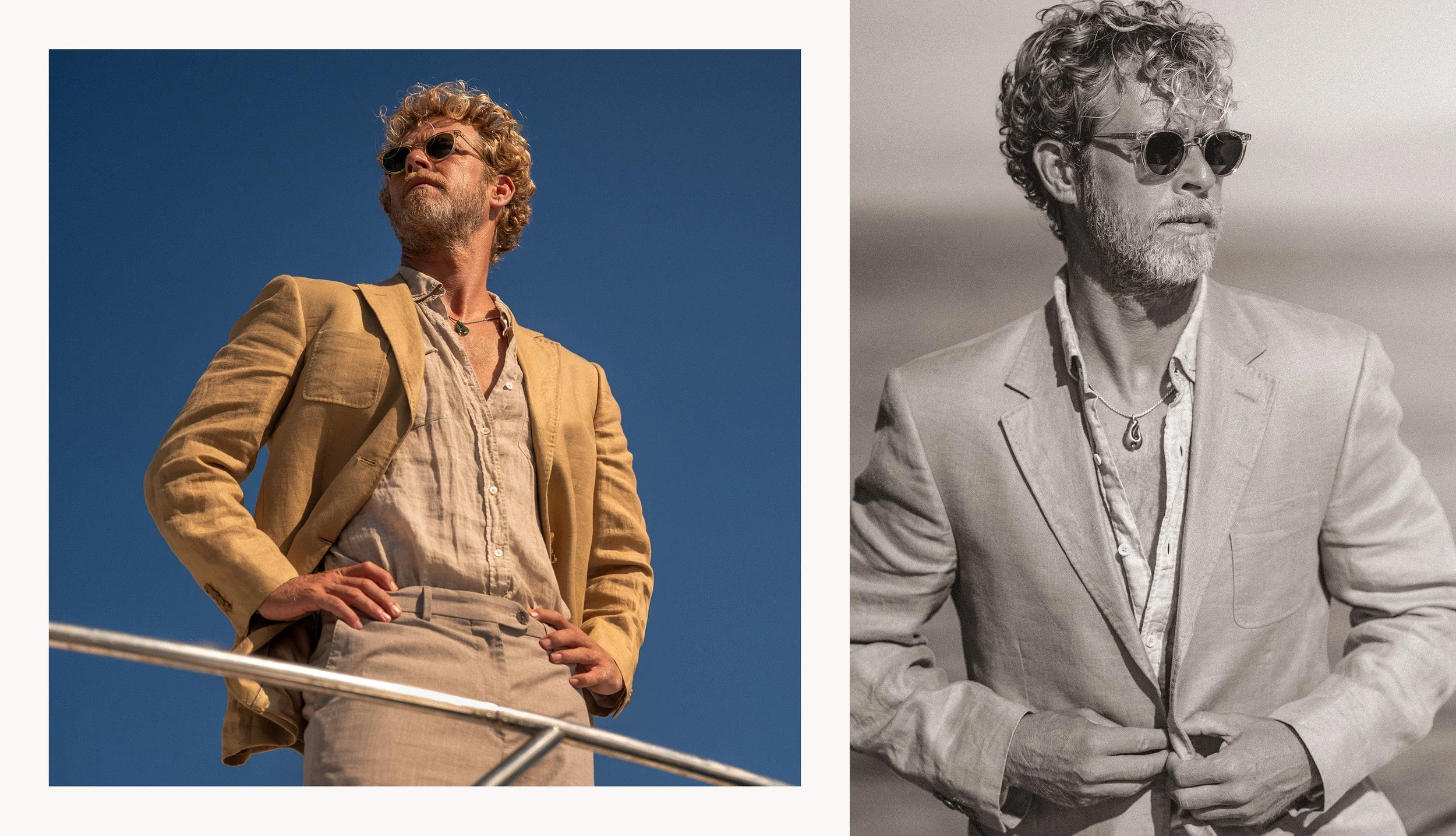 A man with curly hair, a beard, and sunglasses, wearing a light-colored blazer and shirt, posed with hands on hips against a clear blue sky.