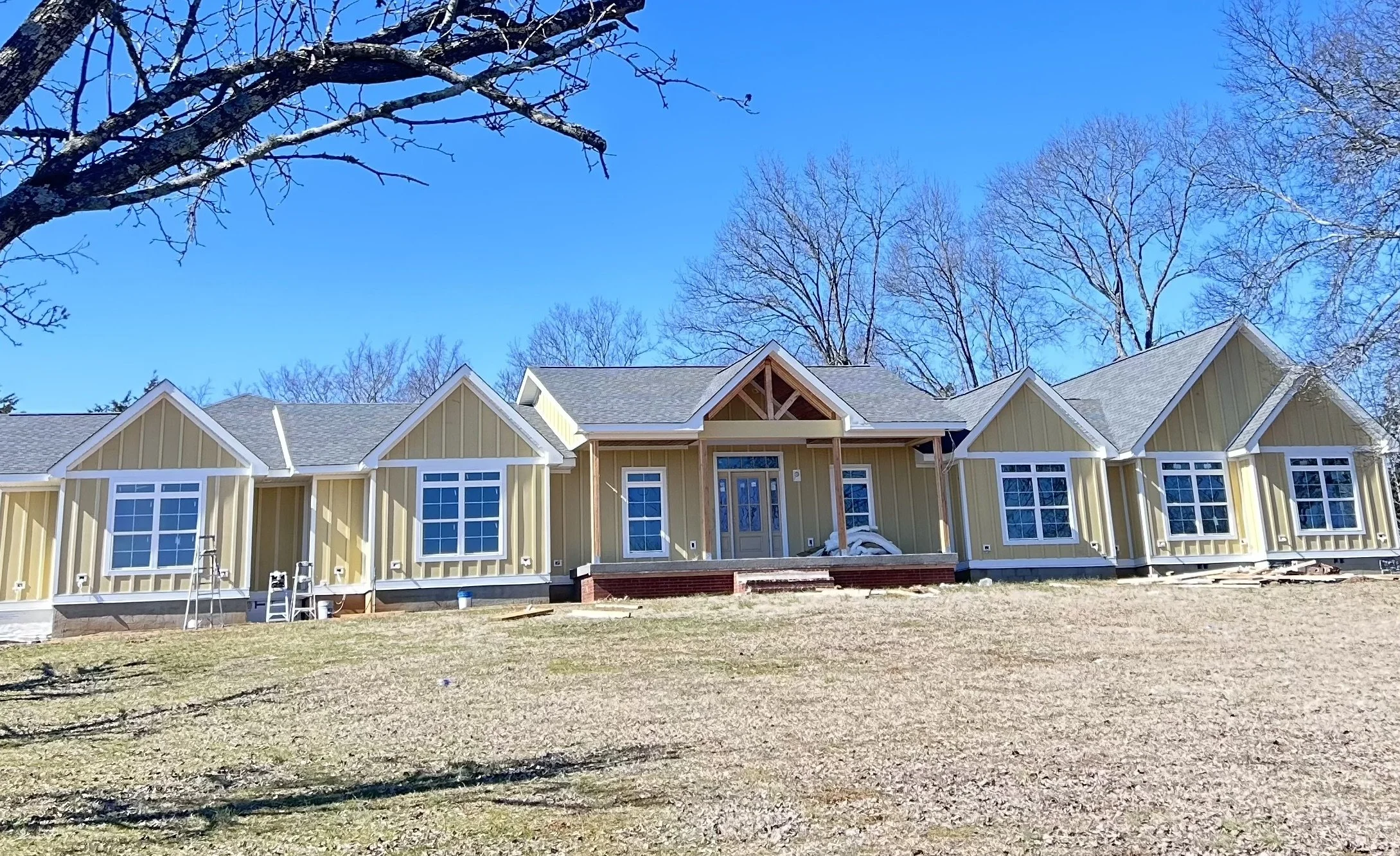 Large residential home exterior featuring fresh white weather-resistant siding paint and professional trim work by O & B Paint in Middle Tennessee.