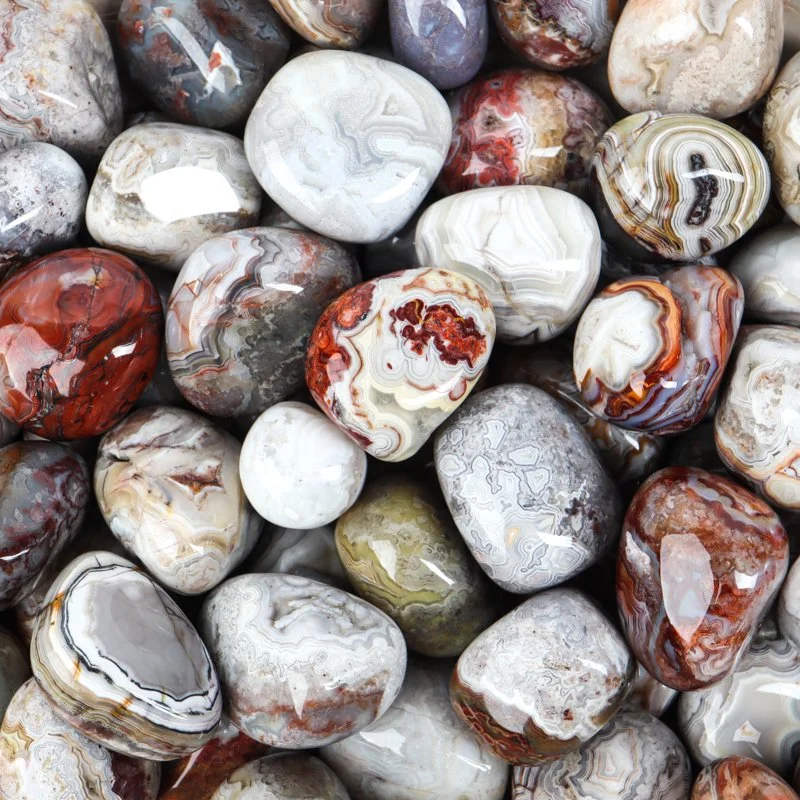 A collection of polished, multicolored semi-precious stones or agates with various natural banding patterns and colors.