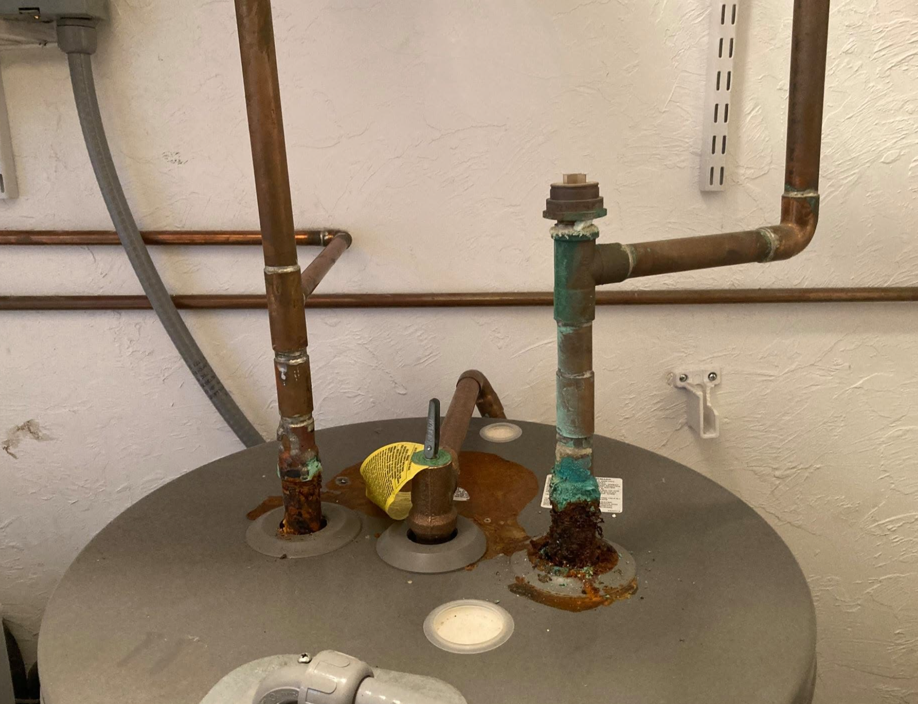 Corroded and leaking water heater in need of replacement, Central Massachusetts