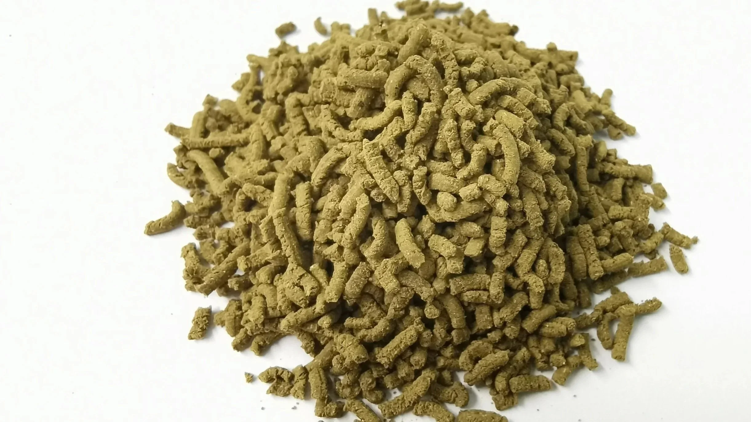A mound of dry, curled, light-brown dog kibble on a white background.