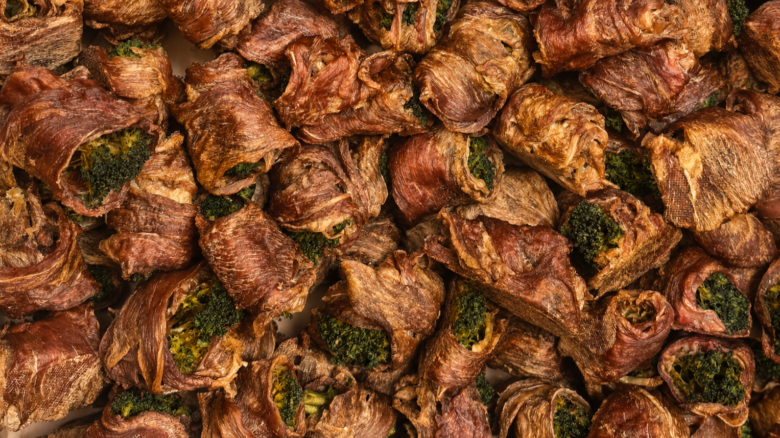 Close-up of cooked broccoli wrapped in thin slices of beef.
