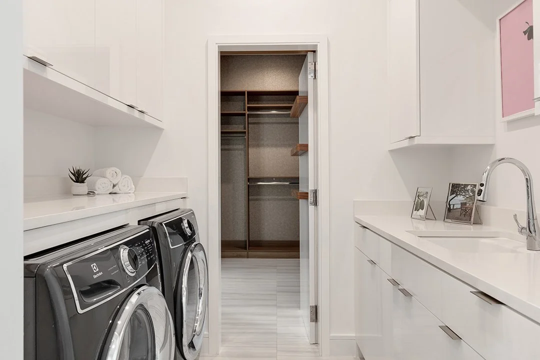 custom modern white laundry room with black washer and dryer