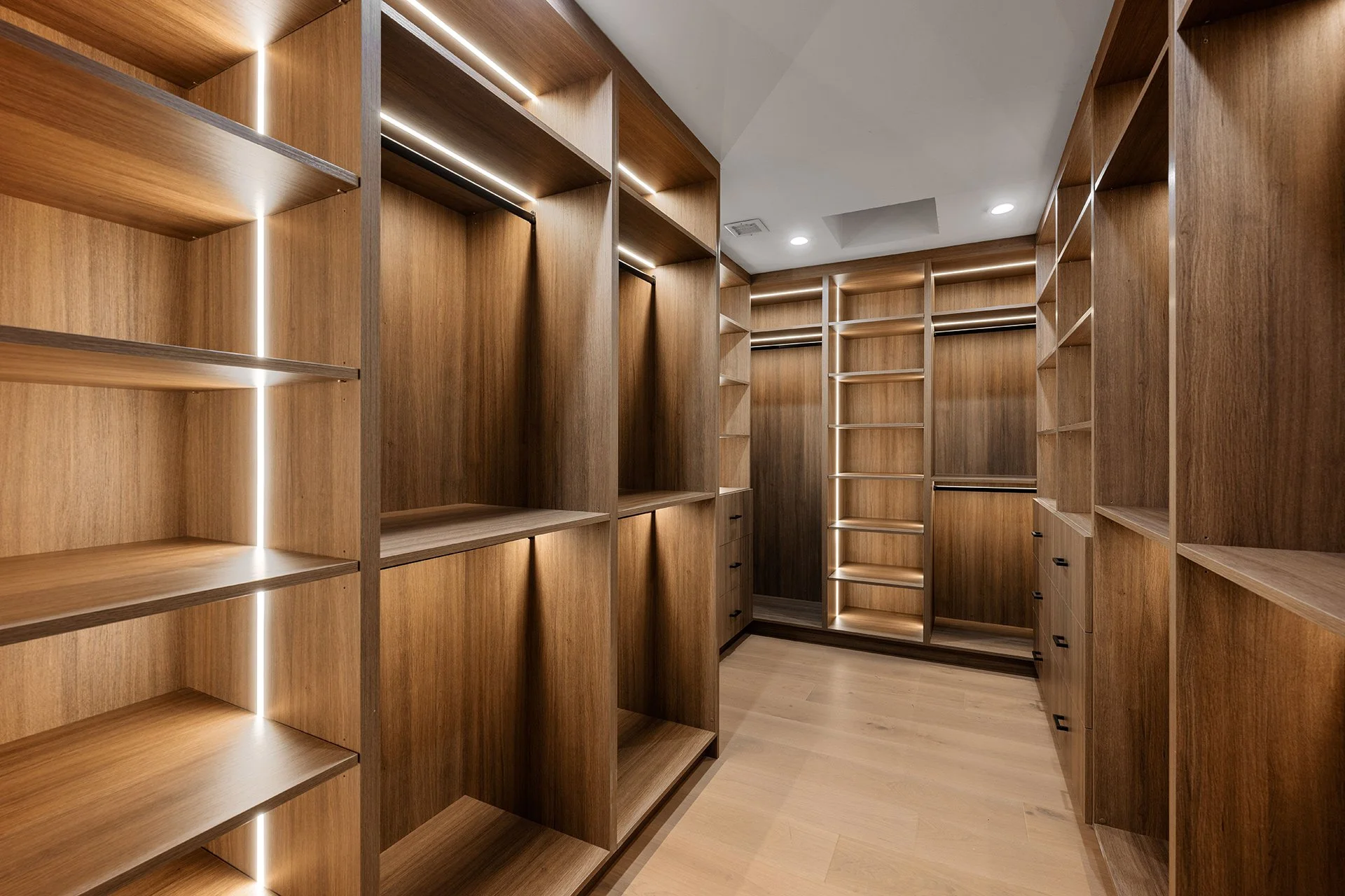 custom primary walk-in closet with lighting details