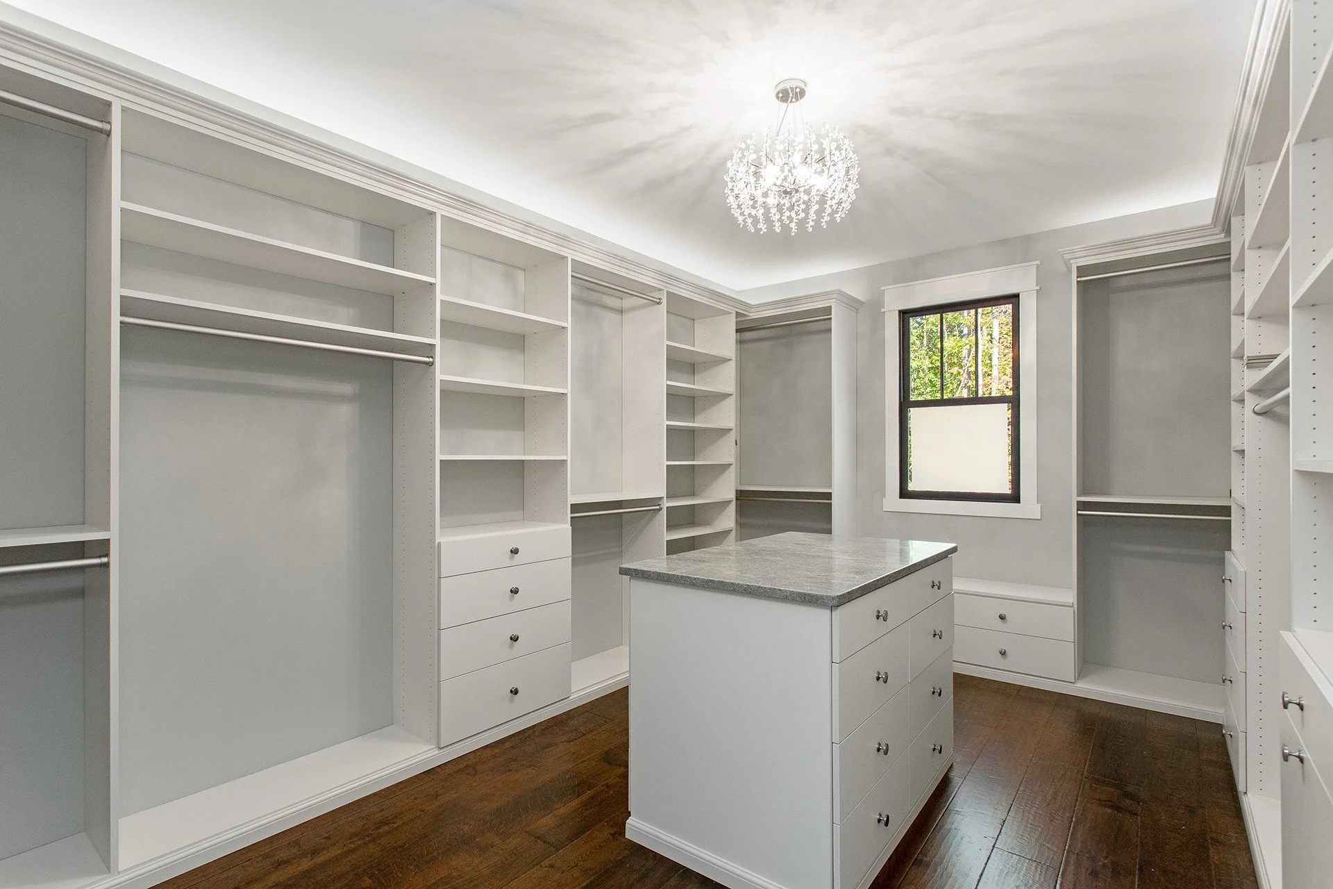 walk in closet with chandelier and center island