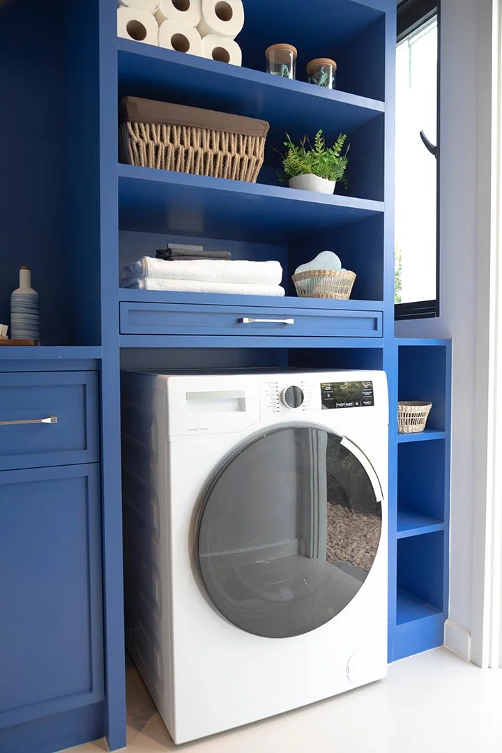 blue custom laundry room cabinets with open shelving and drawers