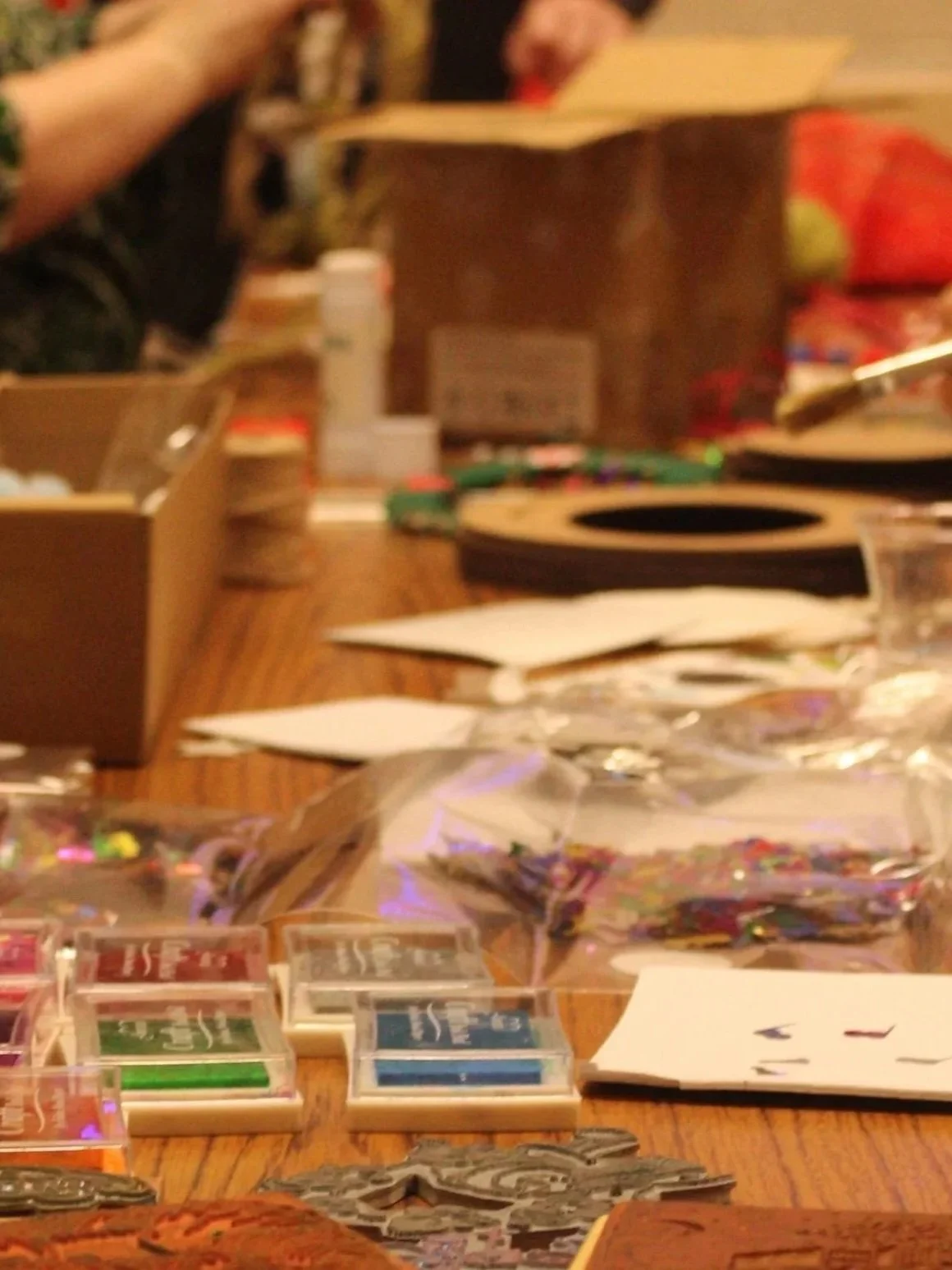 Table with various board games, cards, and game pieces, and a brown paper bag in the background.