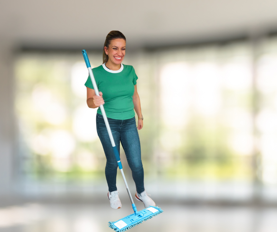 Women smiling while holding a mop, appearing to float in an indoor setting with blurred windows in the background.