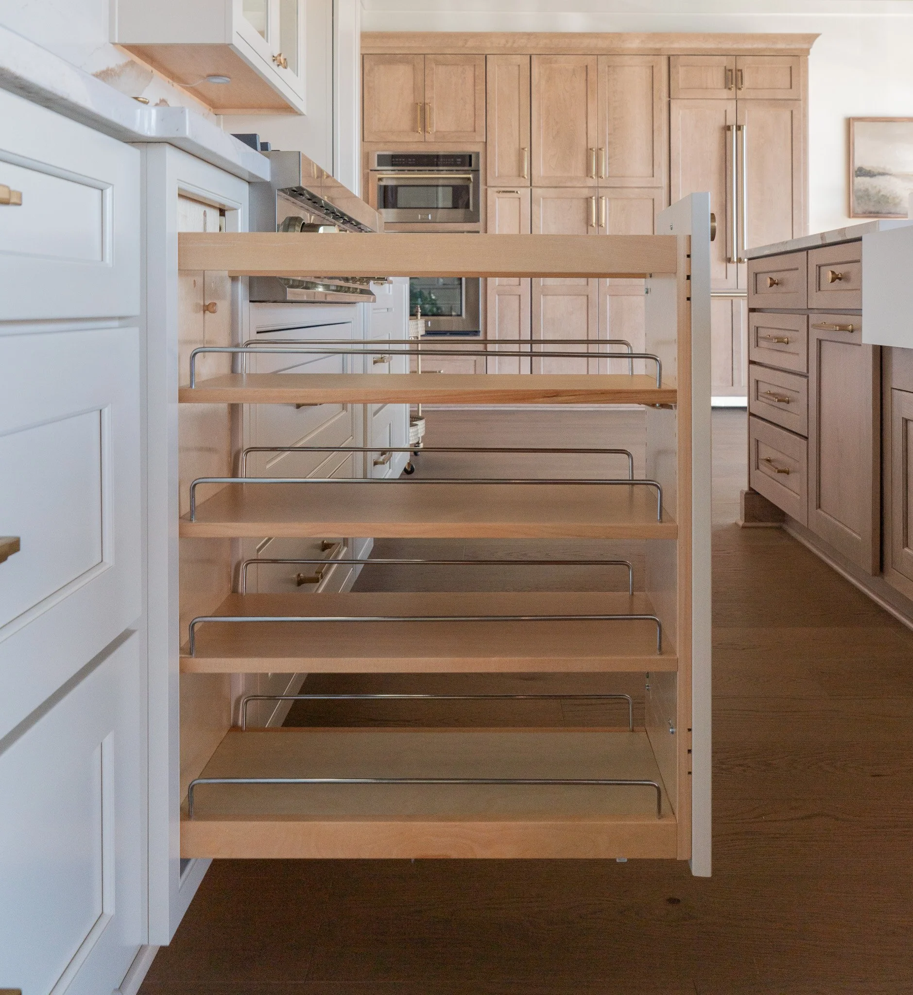 Empty kitchen with white cabinets, wooden drawers, and a wooden kitchen island with metal supports.