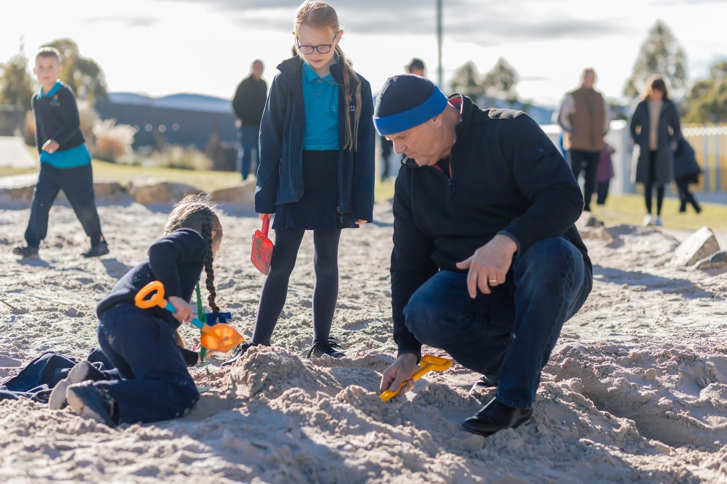 A grandparent playing in the sand with his granddaughter at Grandparent's Day at Northern Christian School