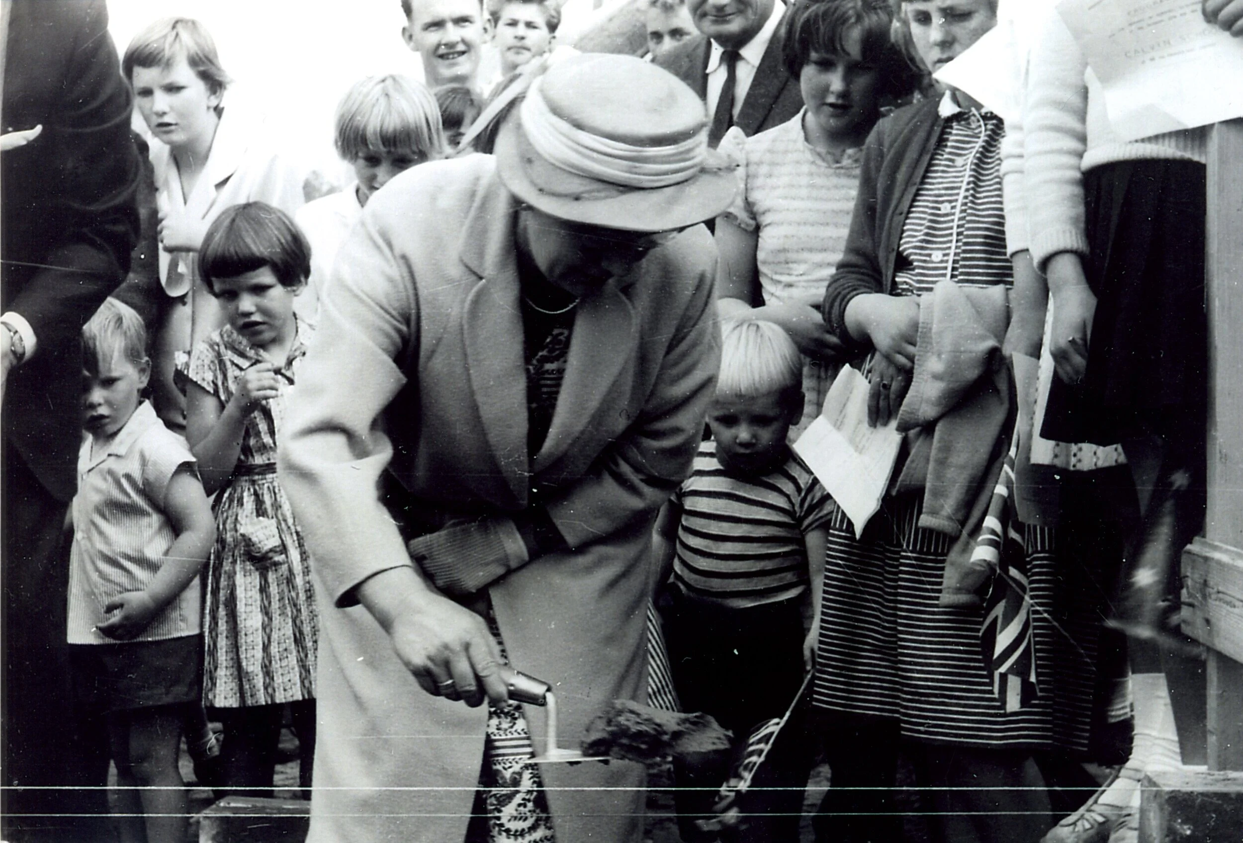 An historic, black and white photo of Mrs Vander Laan laying the first brick at Calvin Christian School