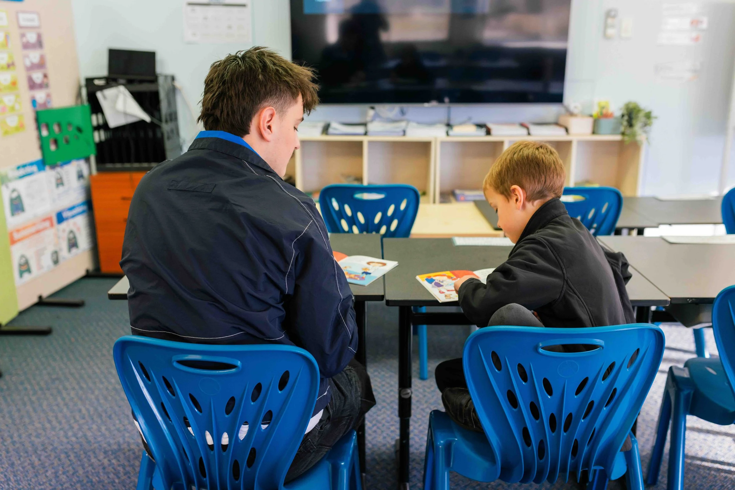 A teacher's aide helping a student in a classroom at Emmanuel Christian School