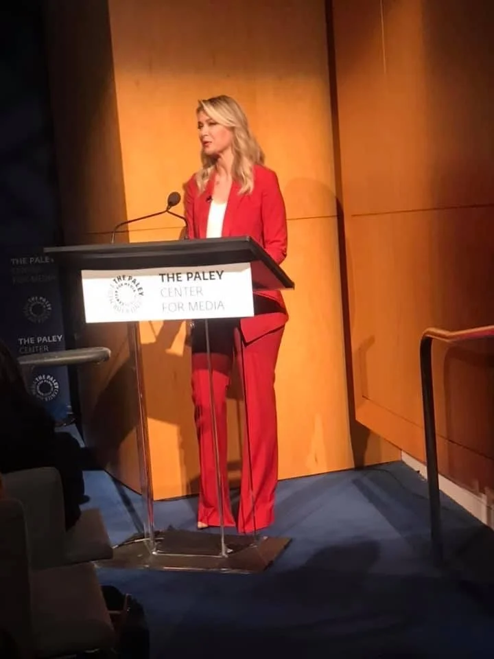 A woman in a red suit speaking at a podium at The Paley Center for Media with Lisa Ling LAPD and CNN