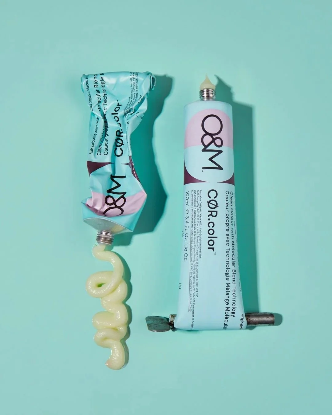 Tube of W8M hair color cream with some cream squeezed out, all on a light green surface.