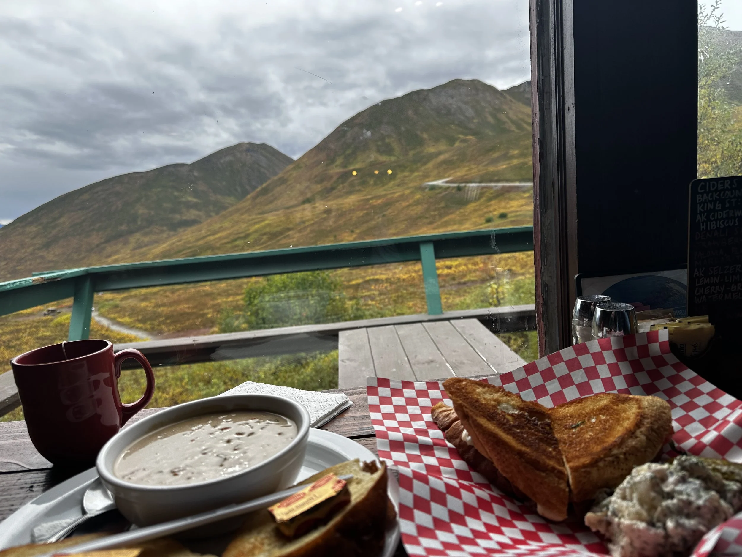 Tomato basil grilled cheese and beet-cheese pickle soup at Hatcher's Pass Lodge, with mountain views through the window