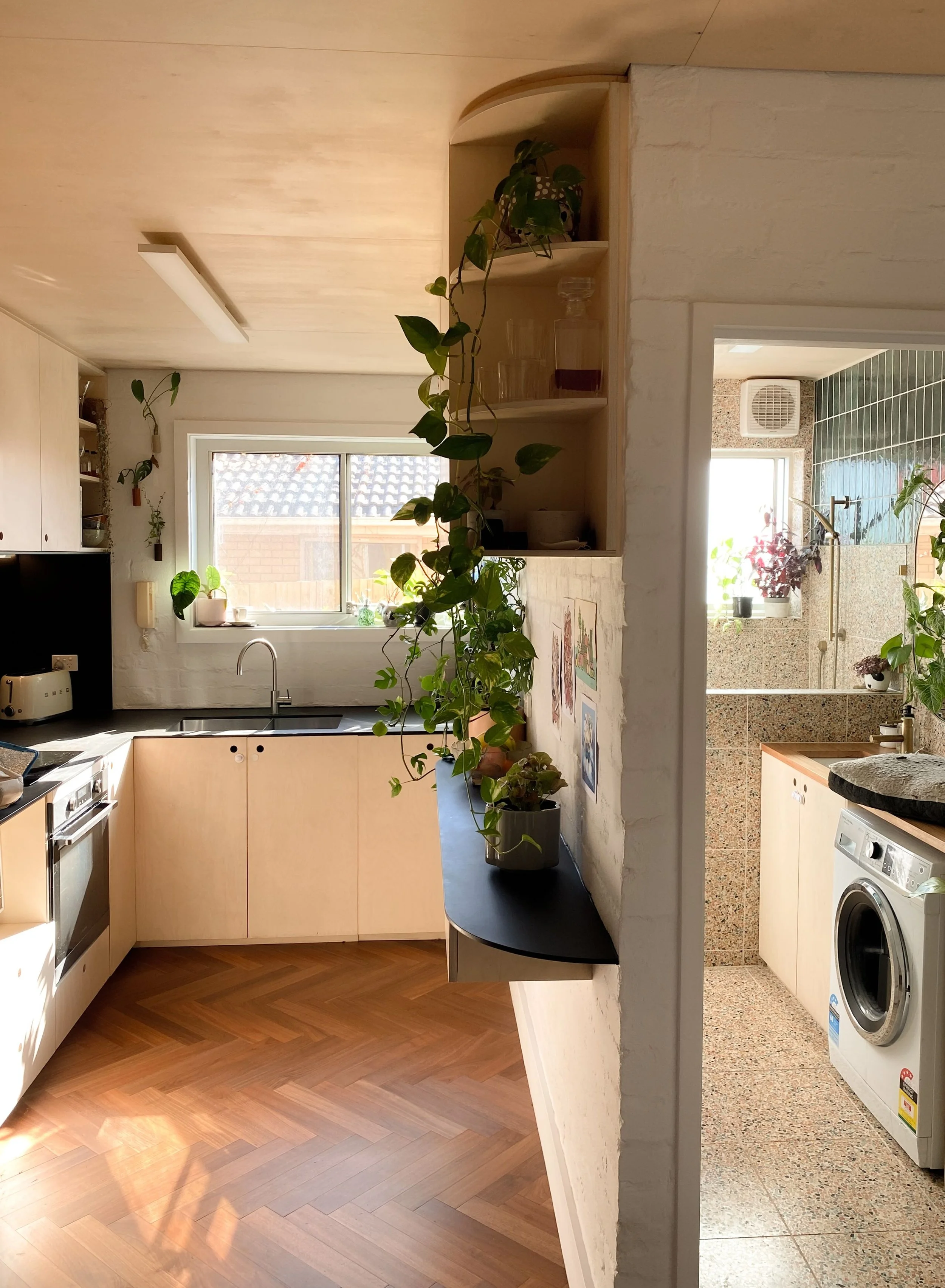 View across the herringbone timber floor through the kitchen into the laundry