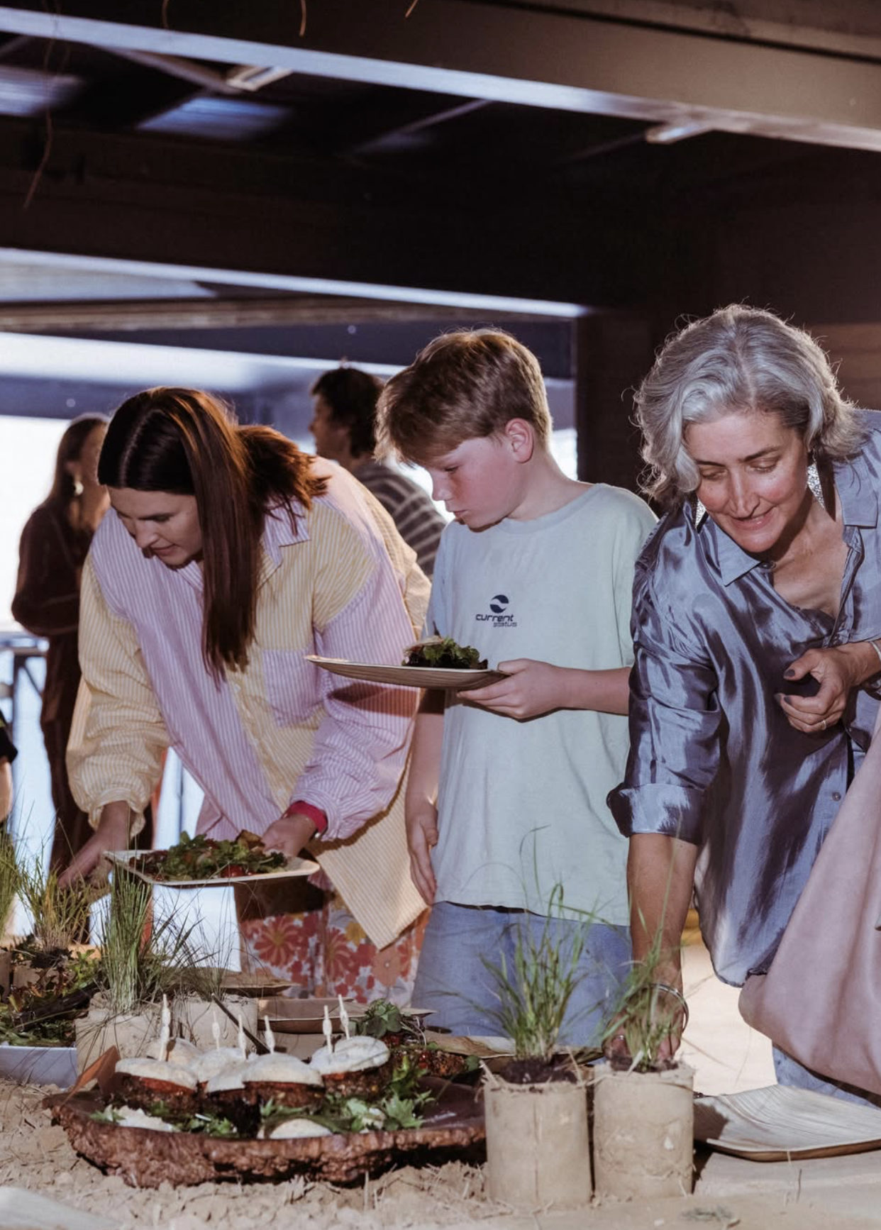 Guests of all ages lining up to fill their plates at the communal table
