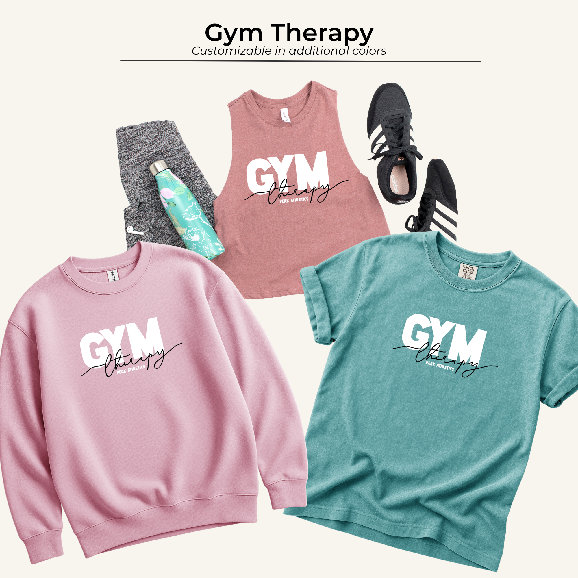 Pink and teal gym sweatshirts with the words "Gym therapy" printed on them, along with a water bottle, black sneakers, black and white leggings, and a teal athletic shirt.