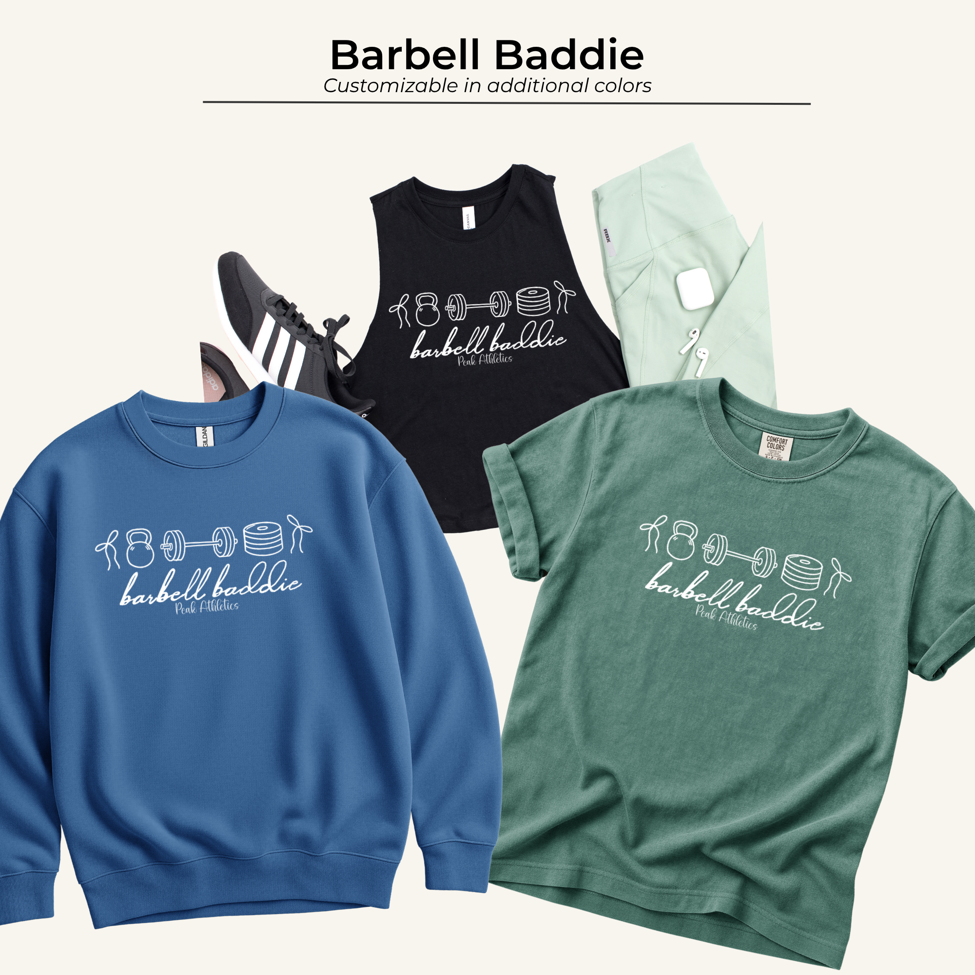 Various clothing items including a black tank top with weightlifting icons and text, a green sweatshirt with earbuds and a smartphone on top, a blue sweatshirt, and a green shirt displayed on a white background.
