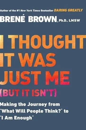 Book cover for 'I Thought It Was Just Me' by Brené Brown, Ph.D., LMSW, with title in large orange and red text and subtitle in smaller white and pink text on a dark blue background.