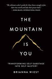 Book cover for 'The Mountain Is You' by Brianna Wiest. It features a simple black background with a gold outline of a mountain and the title text.
