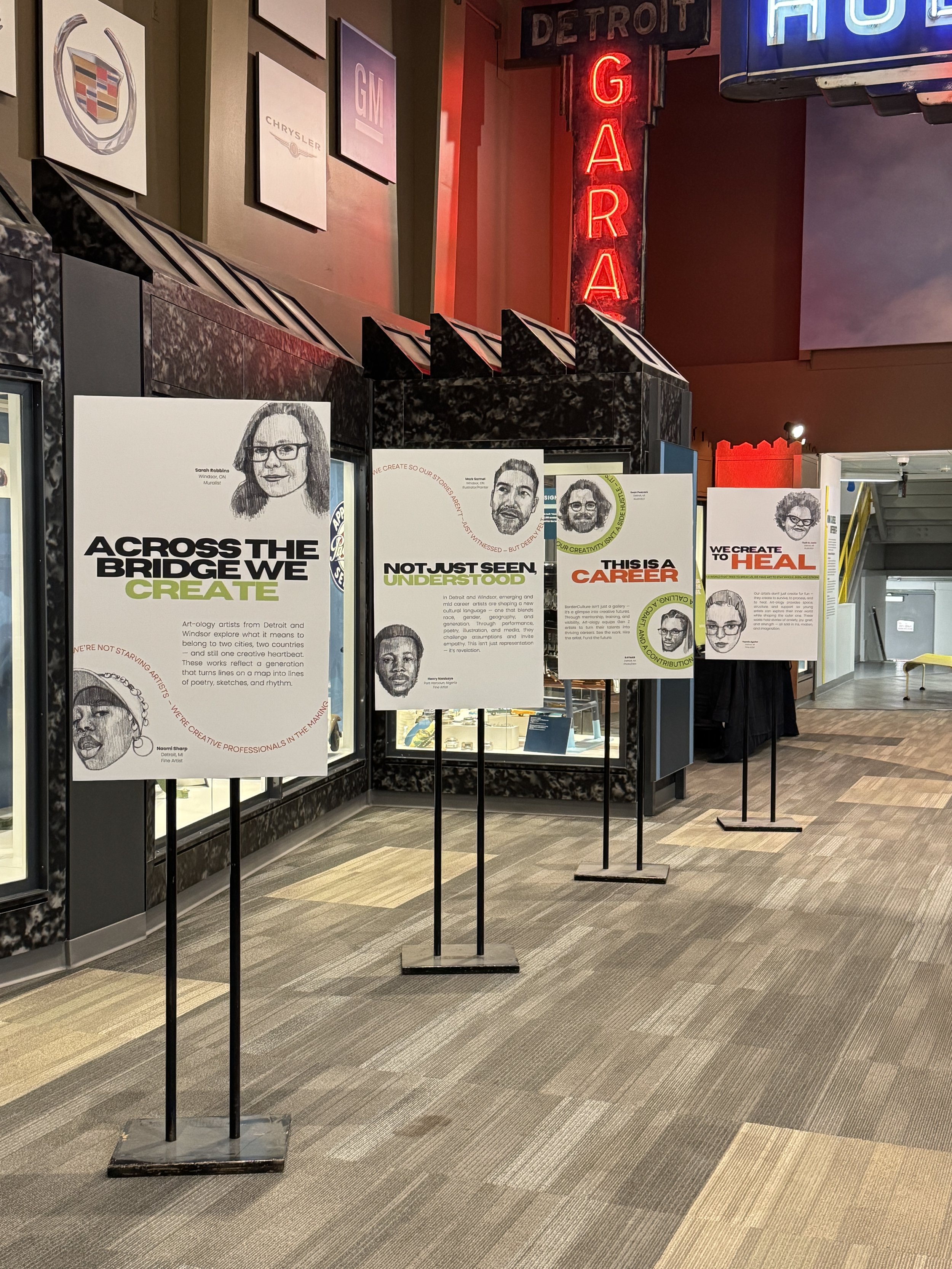 Exhibit display with posters featuring illustrated portraits and text about Detroit artists and career stories at the Detroit Institute of Arts.