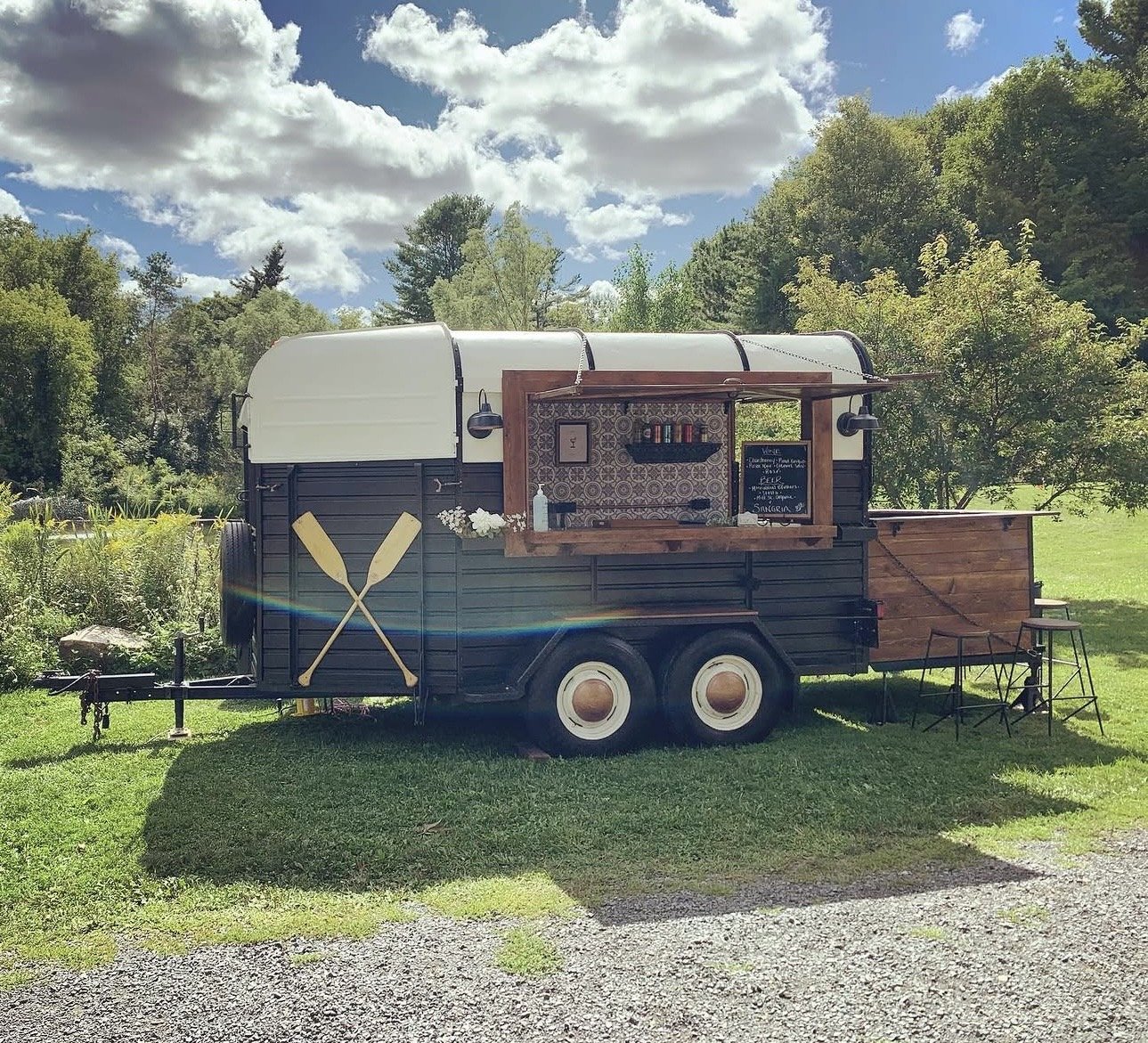 Mobile bar fully equipped with raised seating area and bar stools.