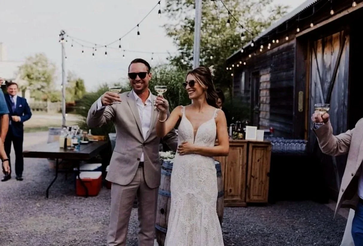 Bride and groom raising champagne glasses at cocktail hour.