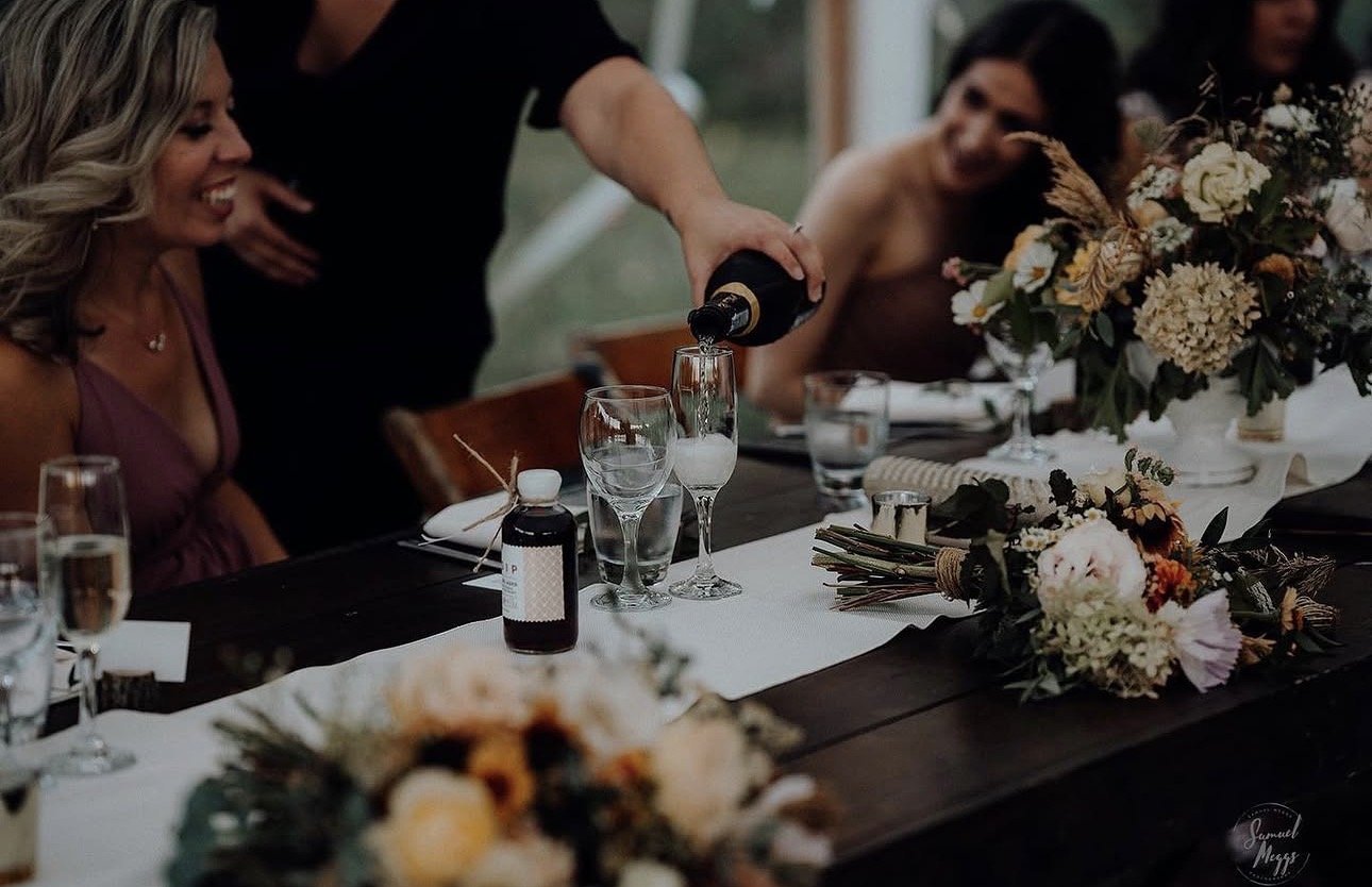 Professional bartender serving drinks during cocktail hour.