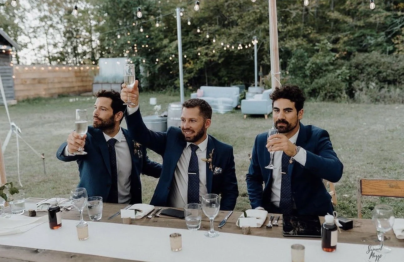 Groomsmen raising a glass during speeches.