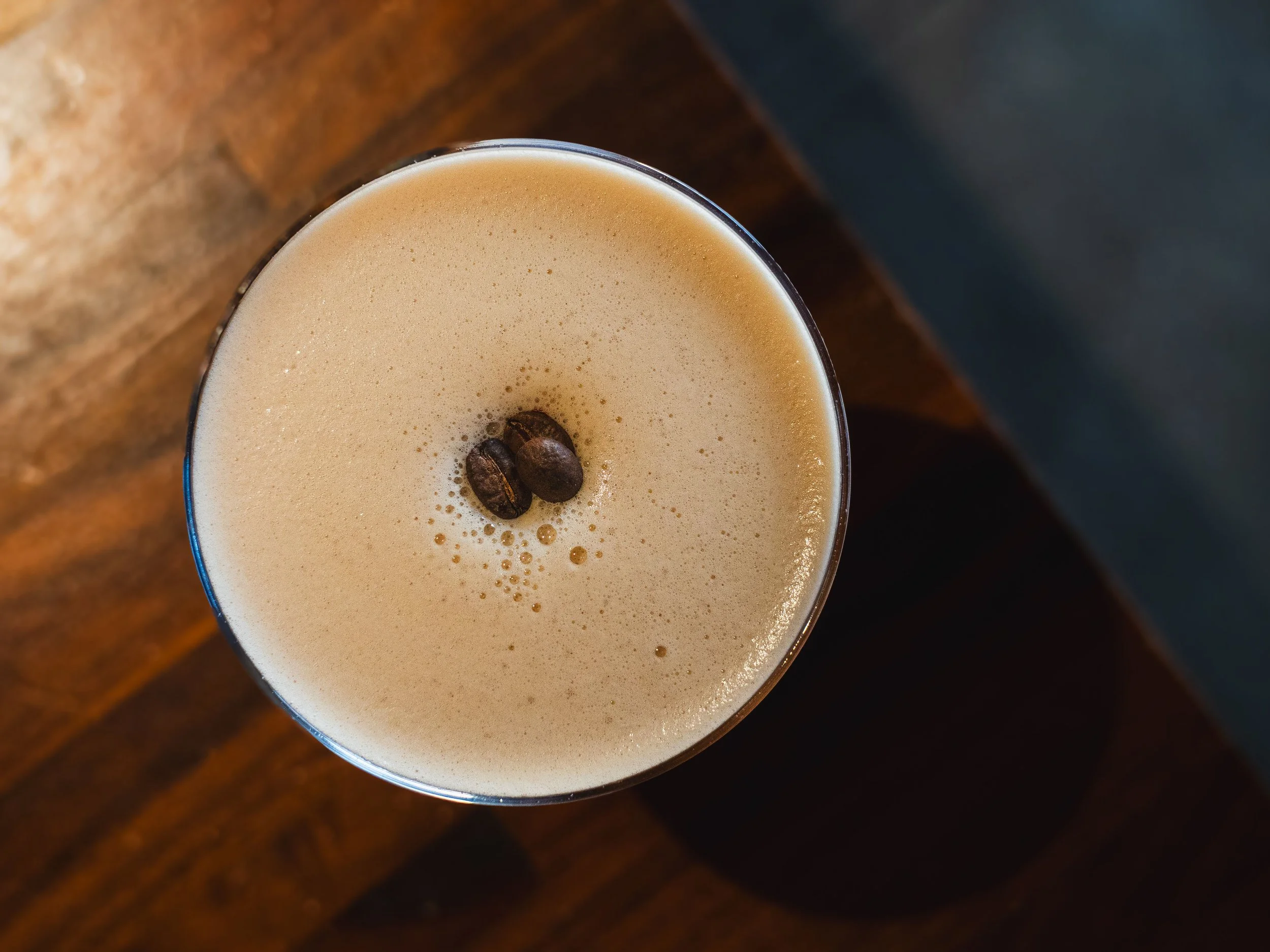 Freshly made espresso martini garnished with coffee beans.