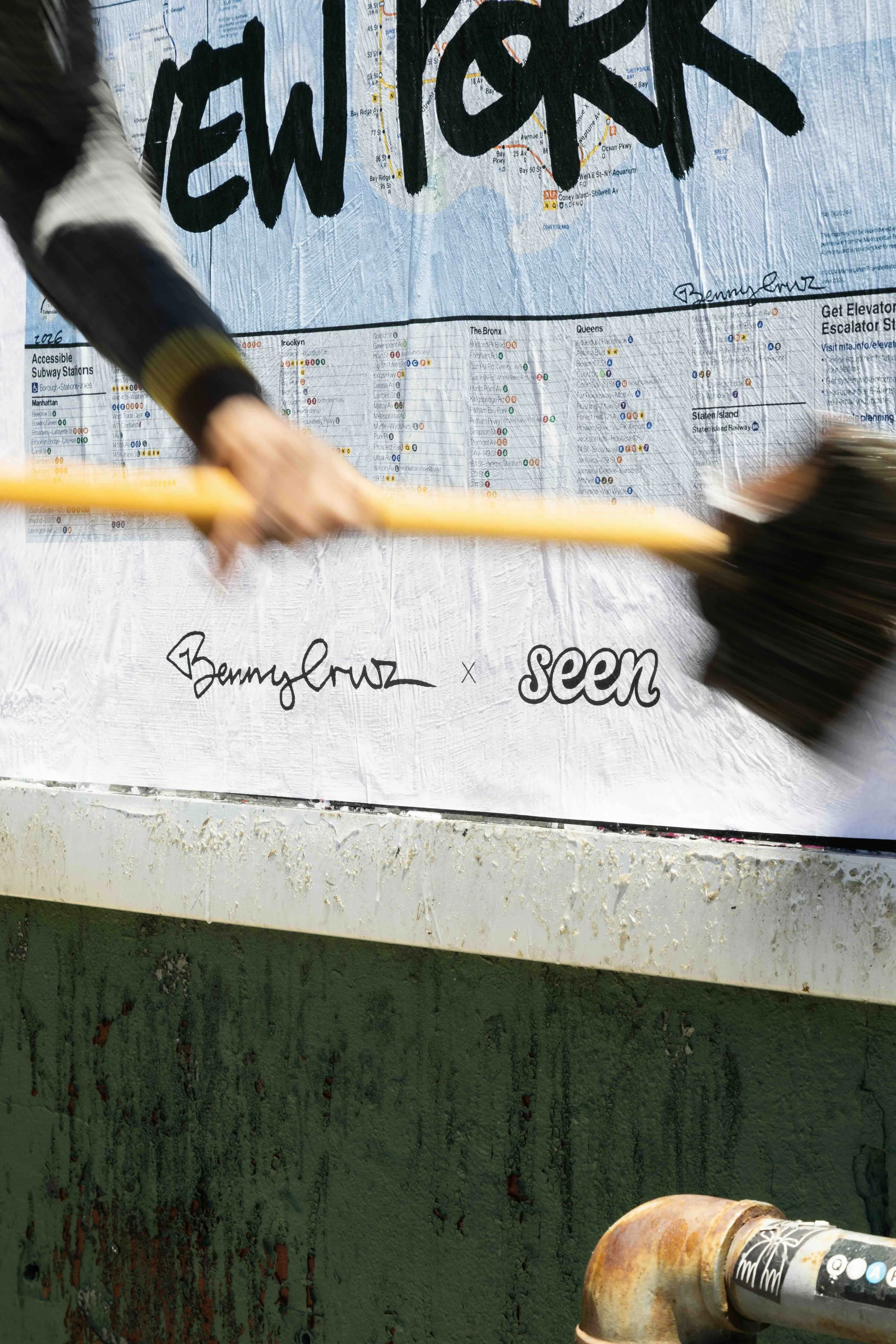 person putting up benny cruz wheat paste art posters