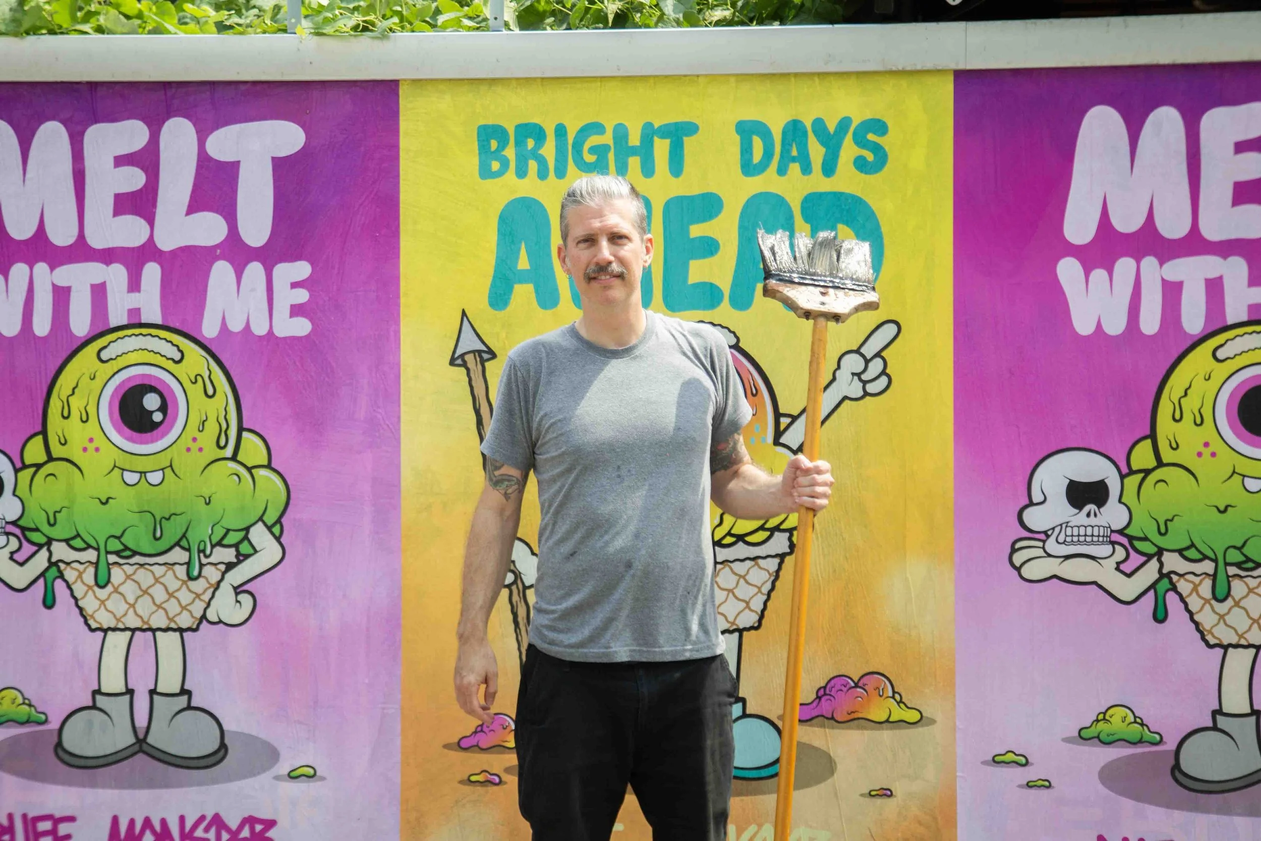Buff Monster standing in front of wheat paste posters