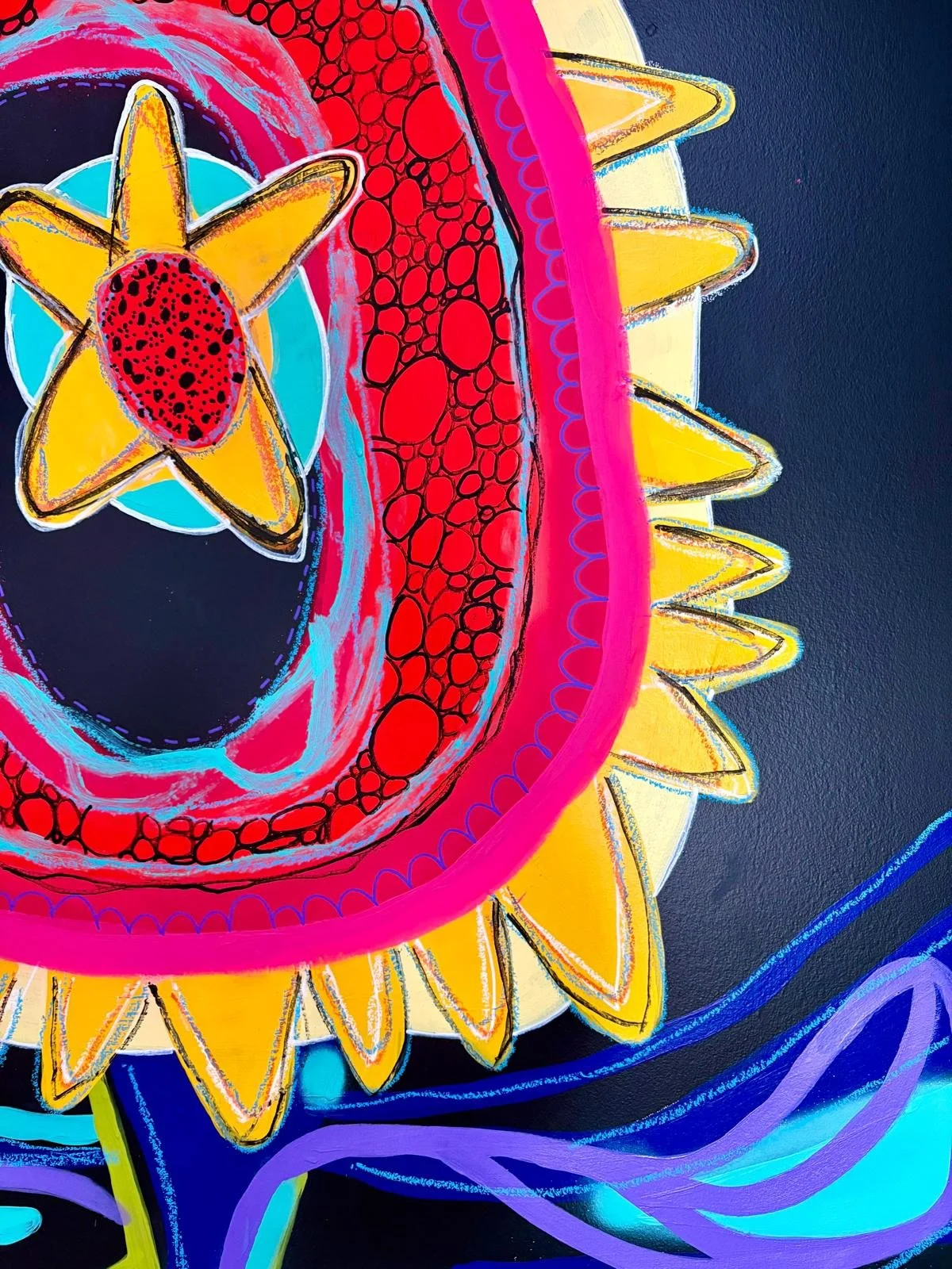Colorful abstract mural of a sunflower with vibrant pink, yellow, red, blue, purple, and black accents.