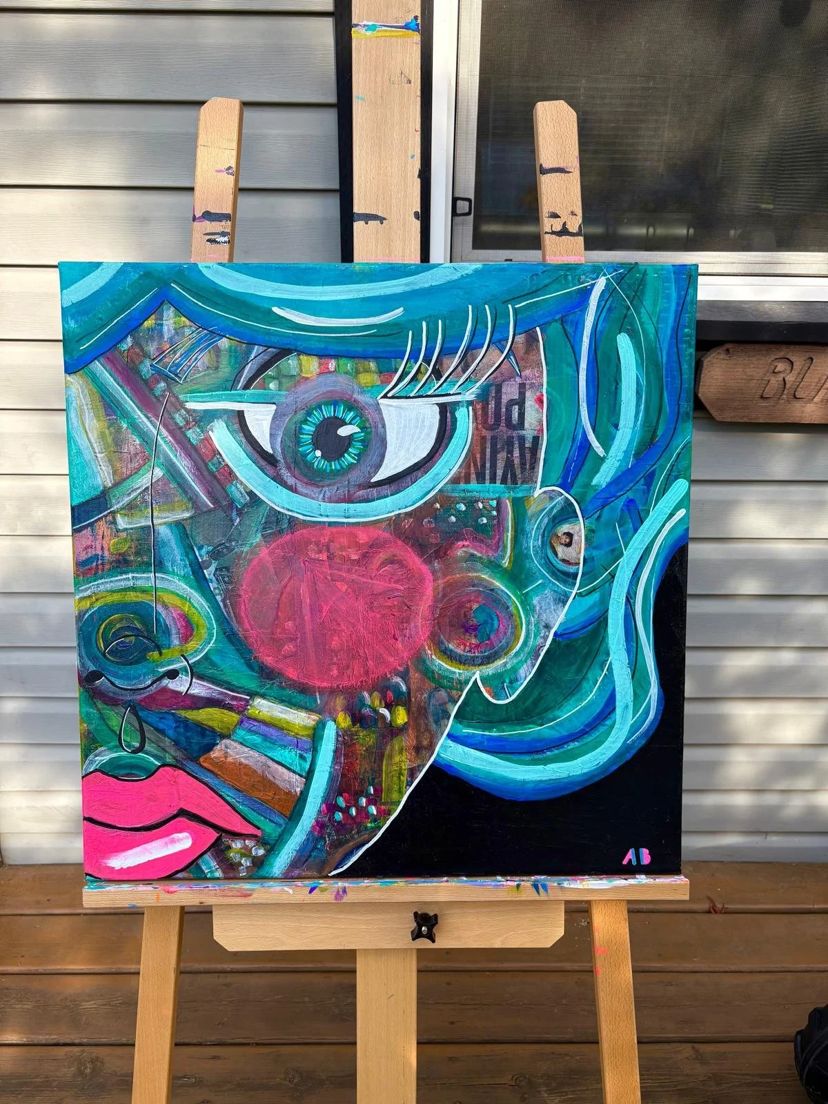 Colorful abstract painting of a face featuring a large eye, red nose, lips, and various patterns and shapes in vibrant colors, signed with initials 'AB'.
