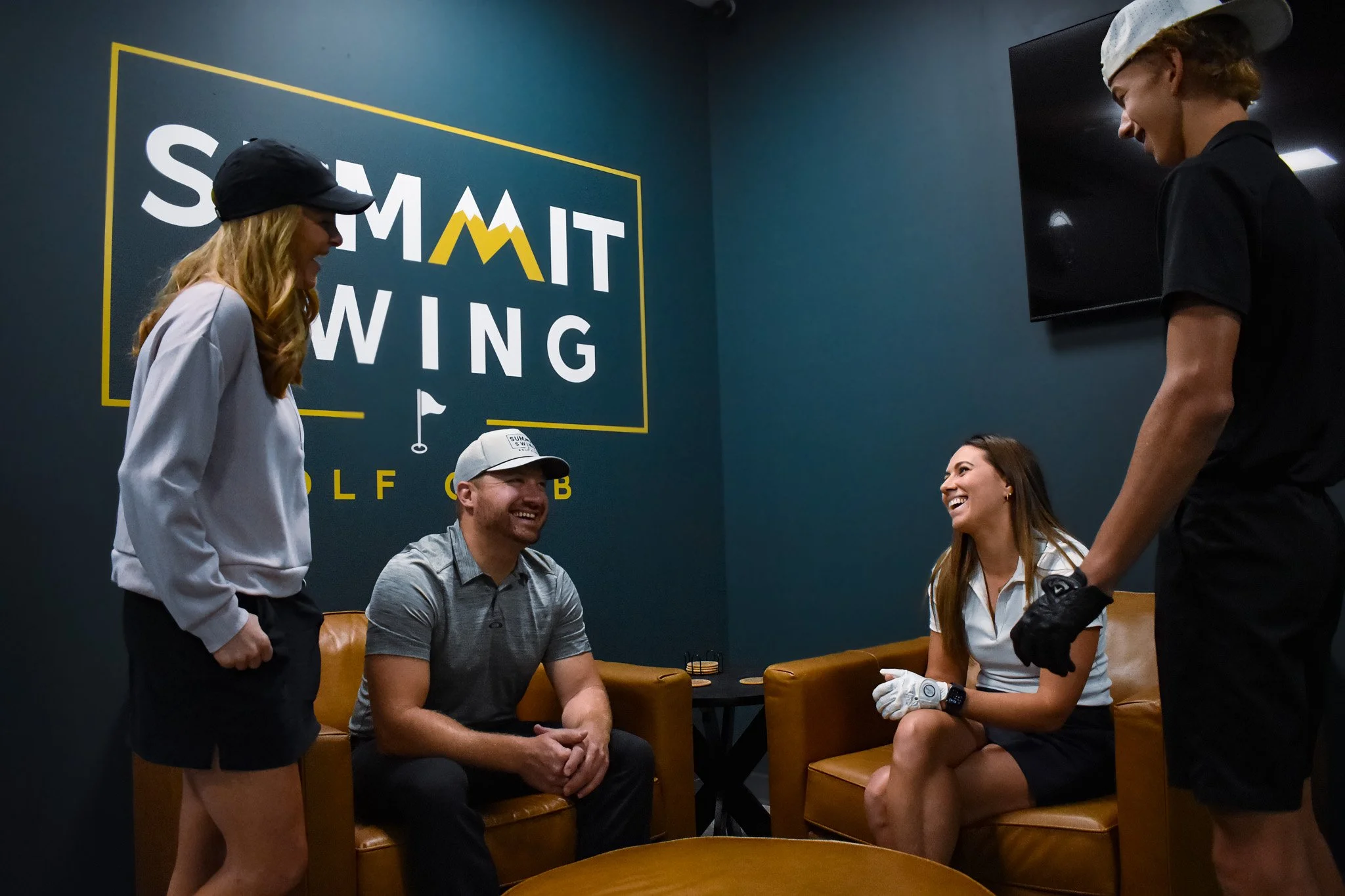 Friends relaxing in the lounge at Summit Swing Golf Club, a 24/7 indoor golf simulator club in Maple Grove, MN
