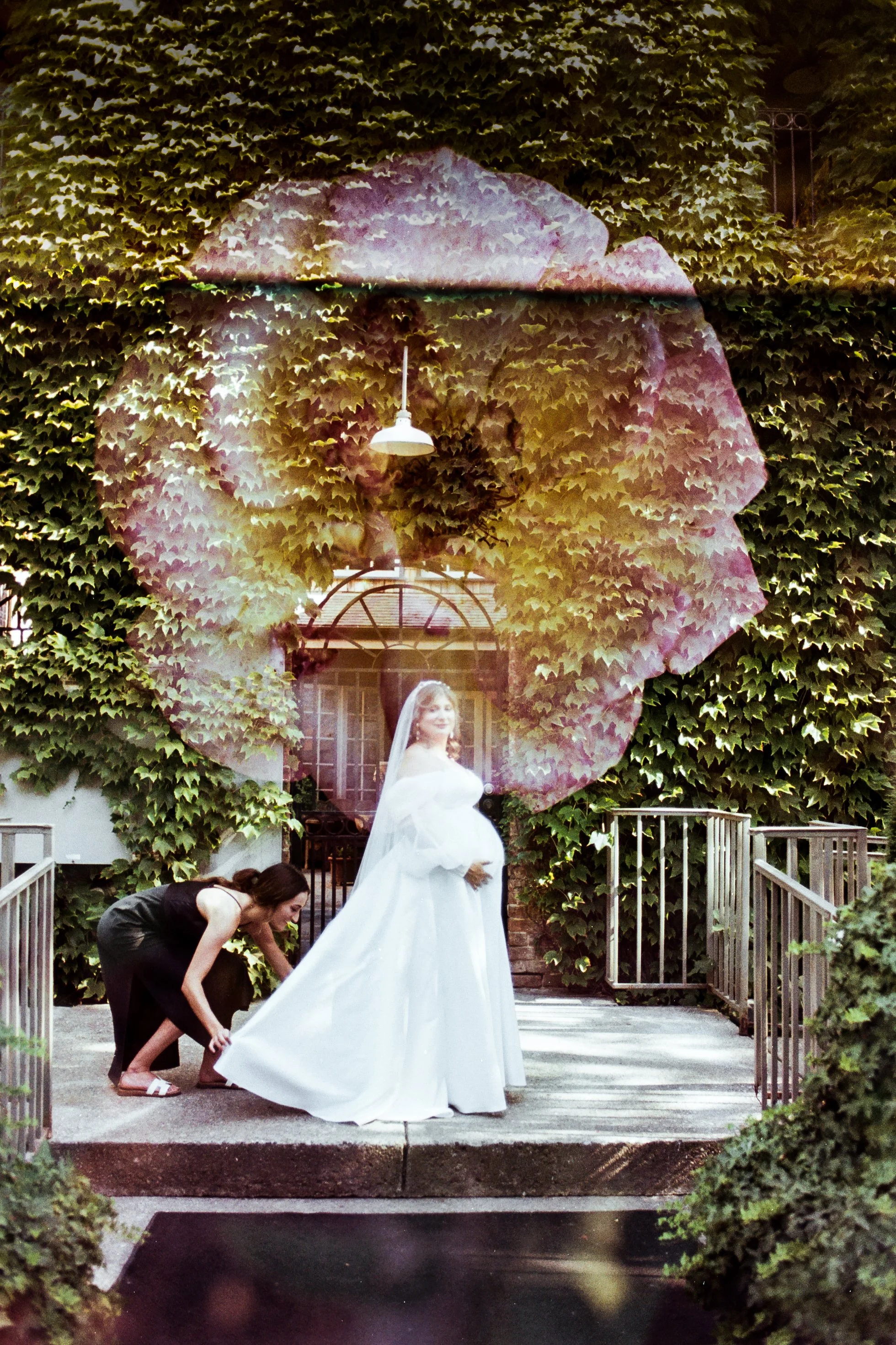 A bride in a white wedding gown stands outside in front of a lush ivy-covered wall, with a woman adjusting her dress. A large, semi-transparent image of a person's silhouette with a bowler hat and glasses is superimposed over the scene.