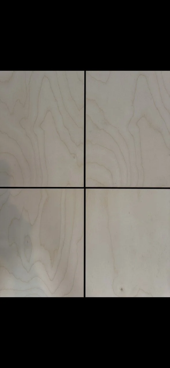 Four beige wooden tiles with light wood grain patterns, arranged in a 2x2 grid with black grout lines.