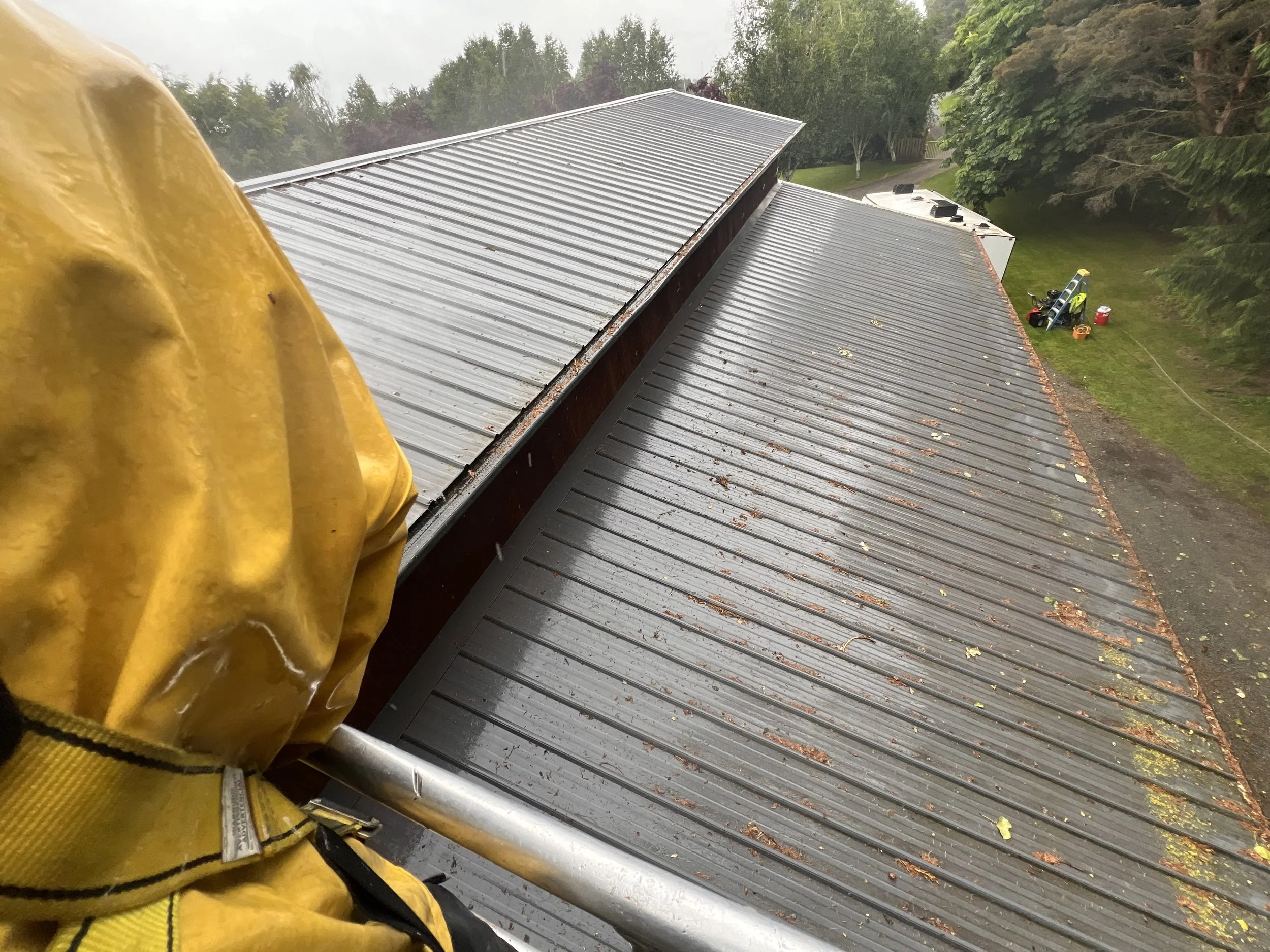 Completed exterior pressure washing on metal roof utilizing moving equipment work platform