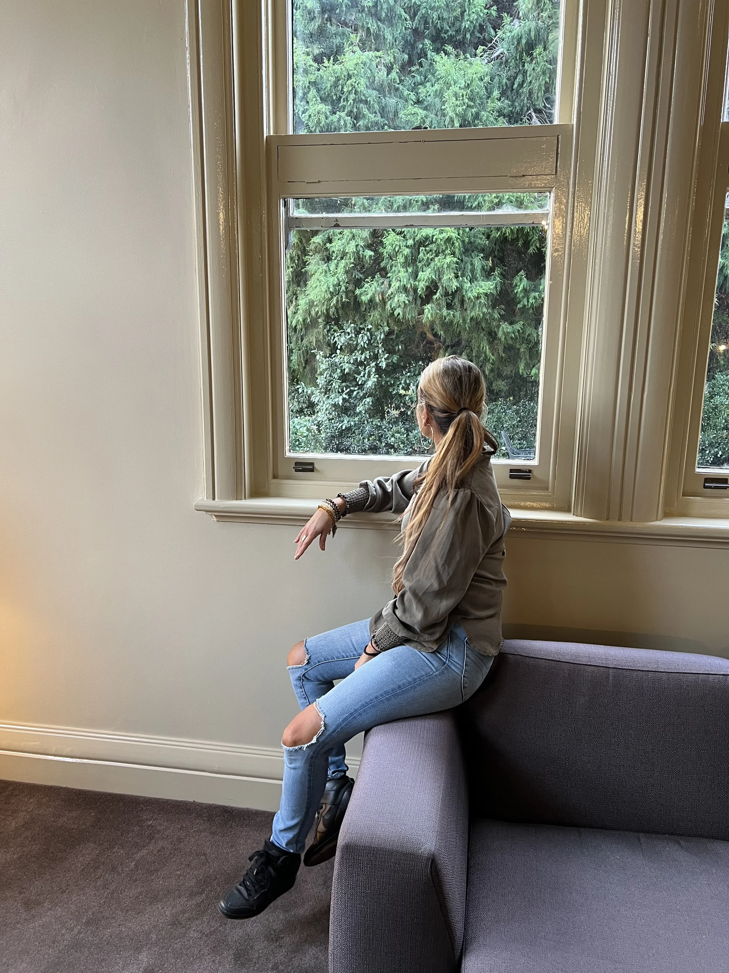 Woman sitting on a sofa looking out a window