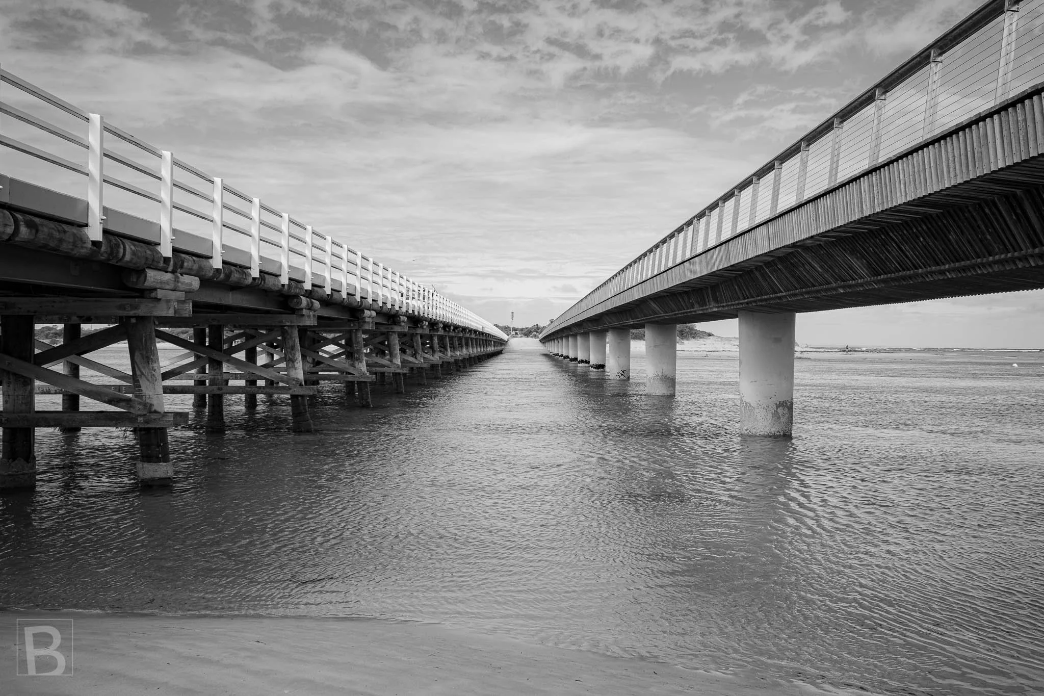 Parallel coastal structures create a narrow passage toward open
water, emphasizing perspective, repetition and distance.
