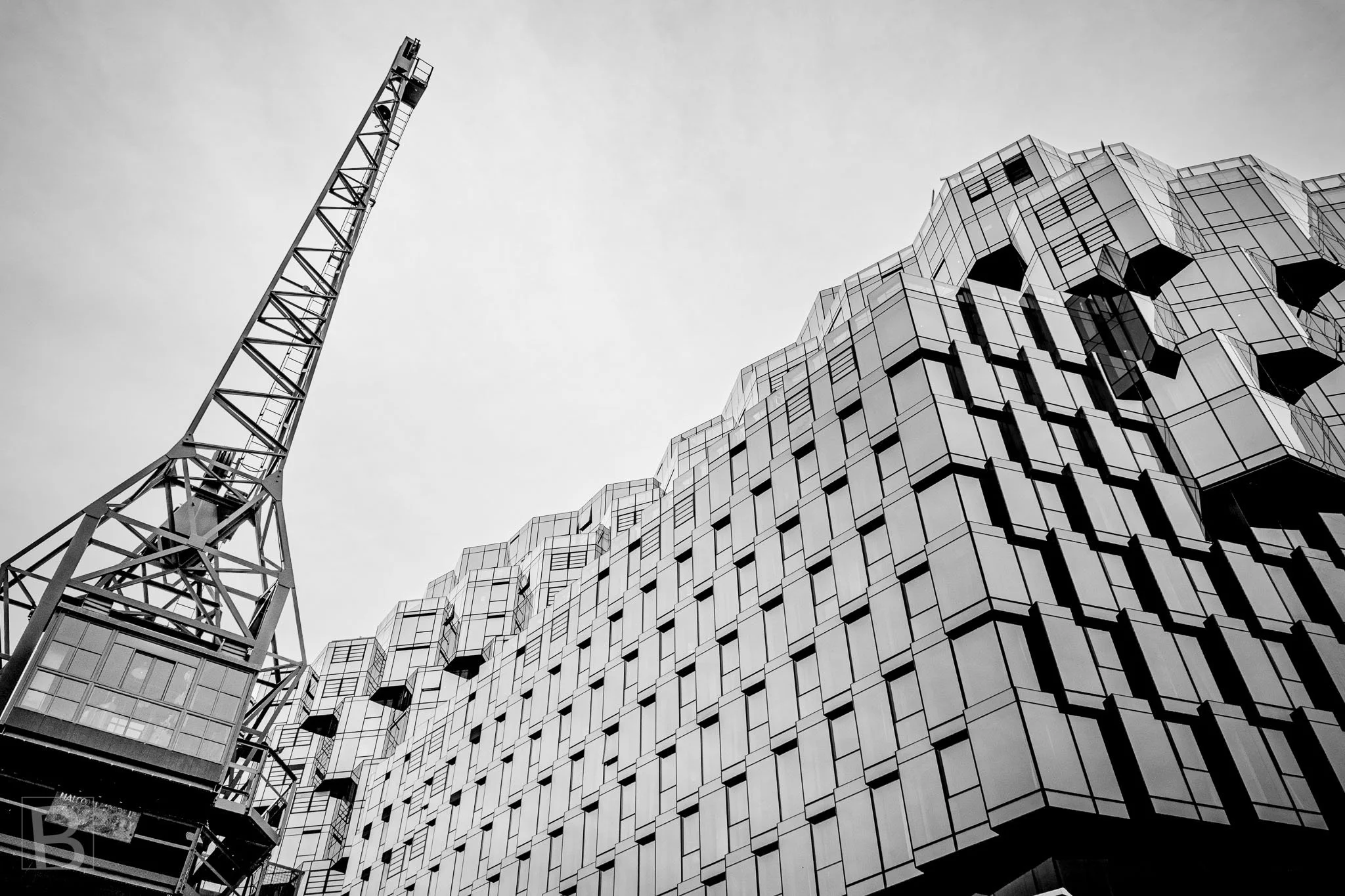 Temporary construction machinery and permanent architecture meet
in a dense composition of latticework, panels and changing city form.