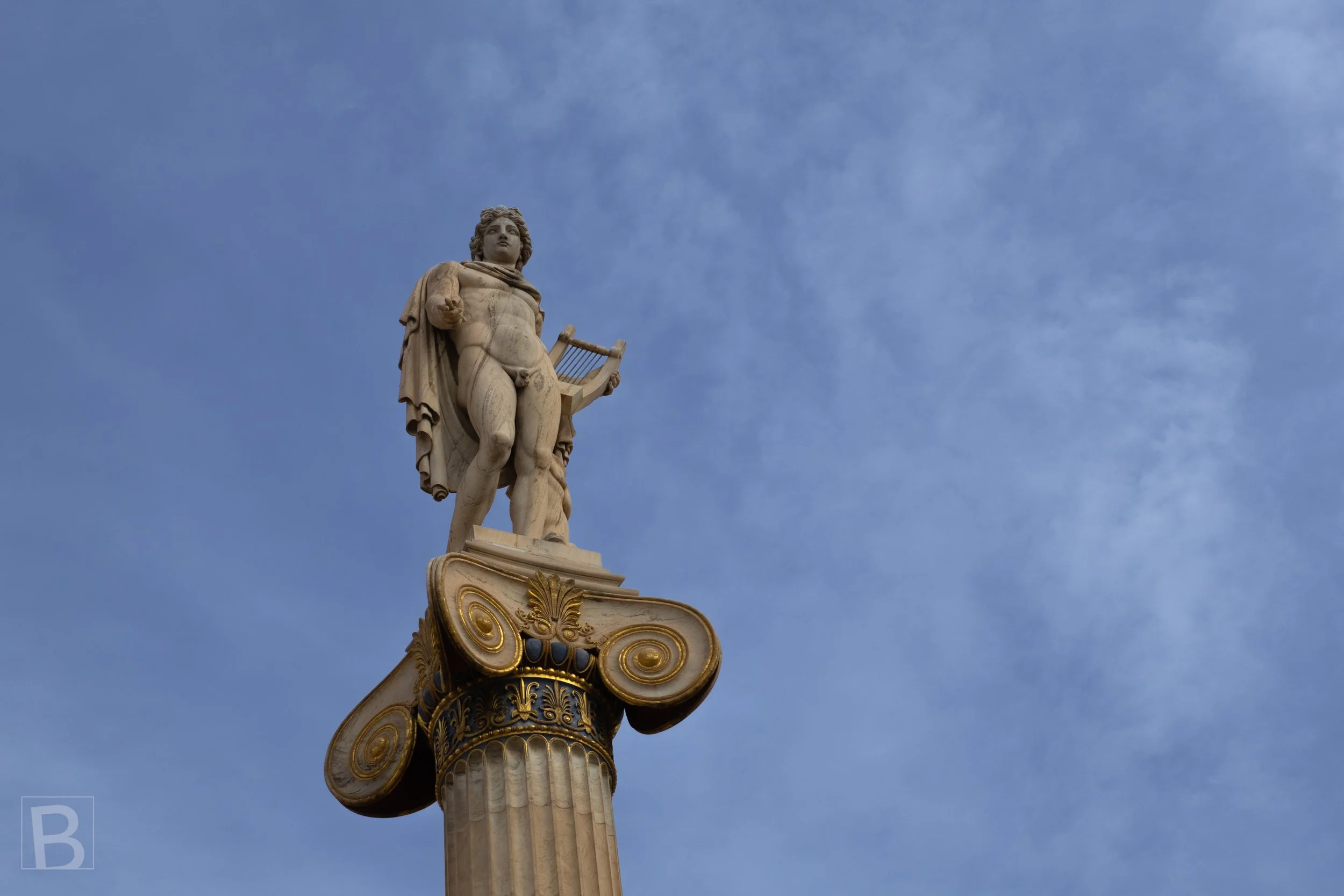 Apollo rises above the city on a carved capital, joining mythology,
sculpture and classical architecture.